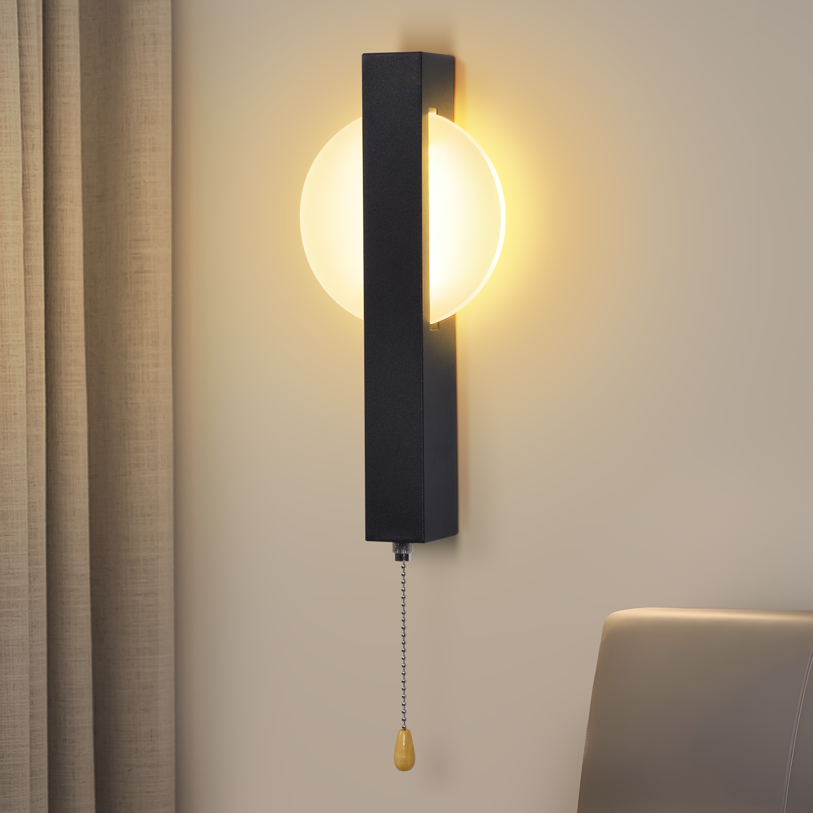 Una lampada da parete con cornice nera e luce a semicerchio. Ha una catena e si monta su un muro beige.