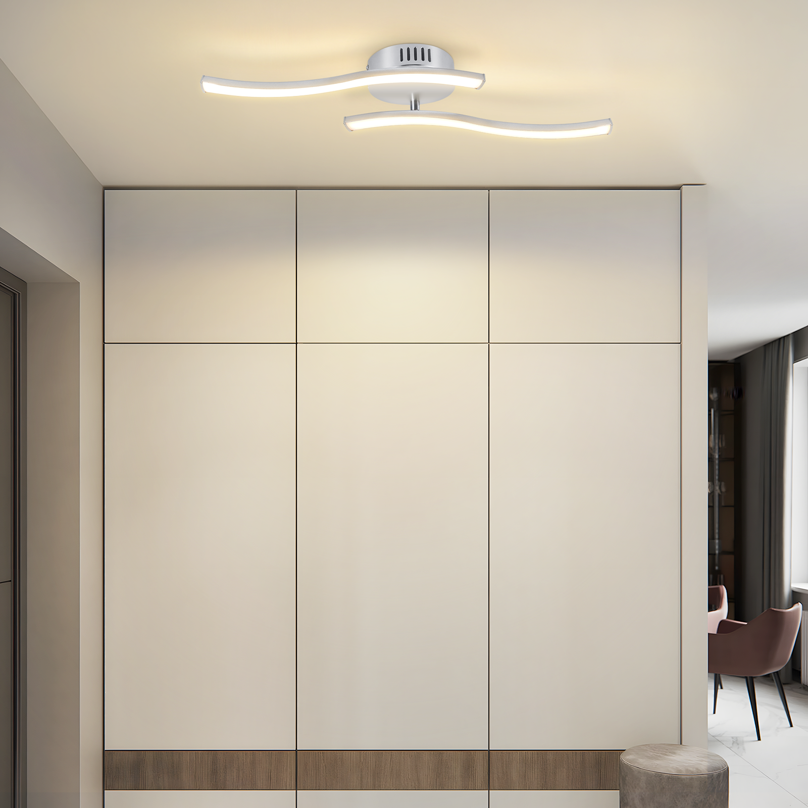 Moderne weiße Deckenleuchte. Großer weißer Schrank. Stuhl und Hocker im Hintergrund. Cremefarbene Wände.