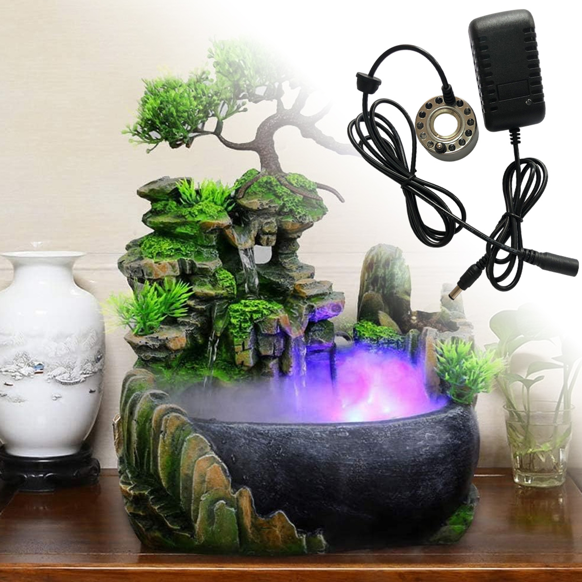 Ein dekorativer Indoor-Brunnen mit einem Bonsai-Baum, Wasserfall und einem schwarzen Netzteil. Das Wasser leuchtet lila.