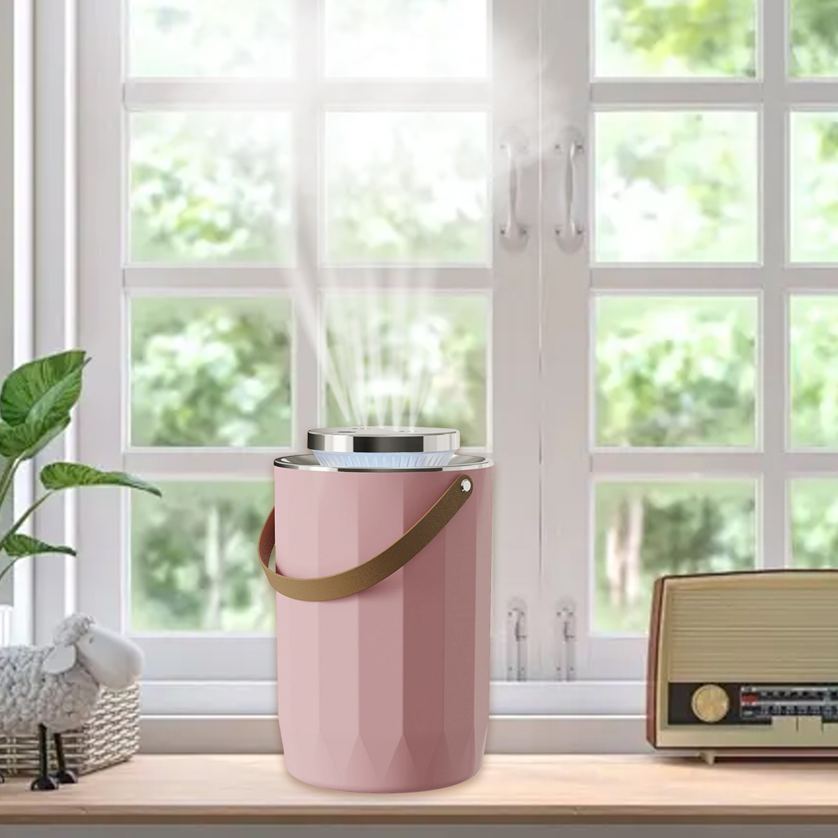 Ein rosa Luftreiniger mit braunem Griff steht auf einer Holzoberfläche. Im Hintergrund ein Fenster mit Schaf-Figur und Radio.