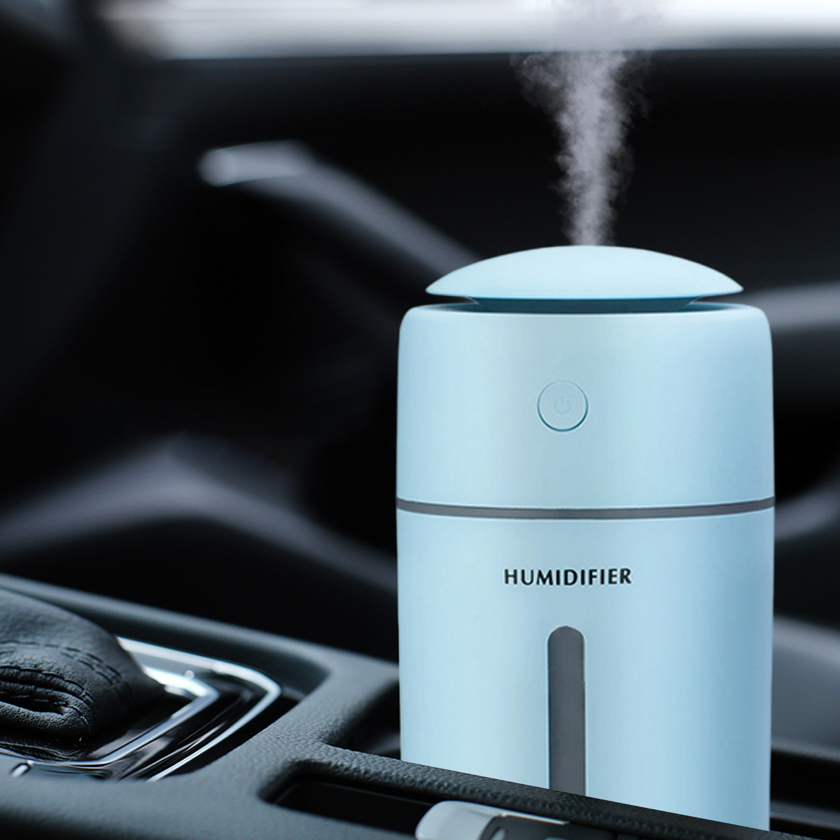 Ein hellblauer Luftbefeuchter im Auto. Er stößt Dampf aus. Der Text 'HUMIDIFIER' ist sichtbar. Der Hintergrund zeigt dunkle Autoteile.