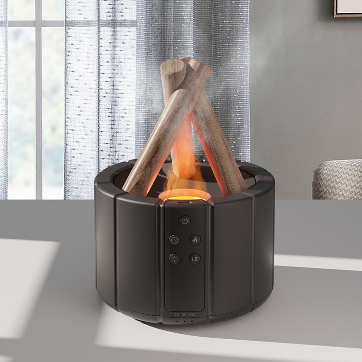 Schwarzer elektrischer Kamin mit Holzscheiten auf weißer Oberfläche. Im Hintergrund sind Vorhänge zu sehen. Das Licht vom Feuer scheint.