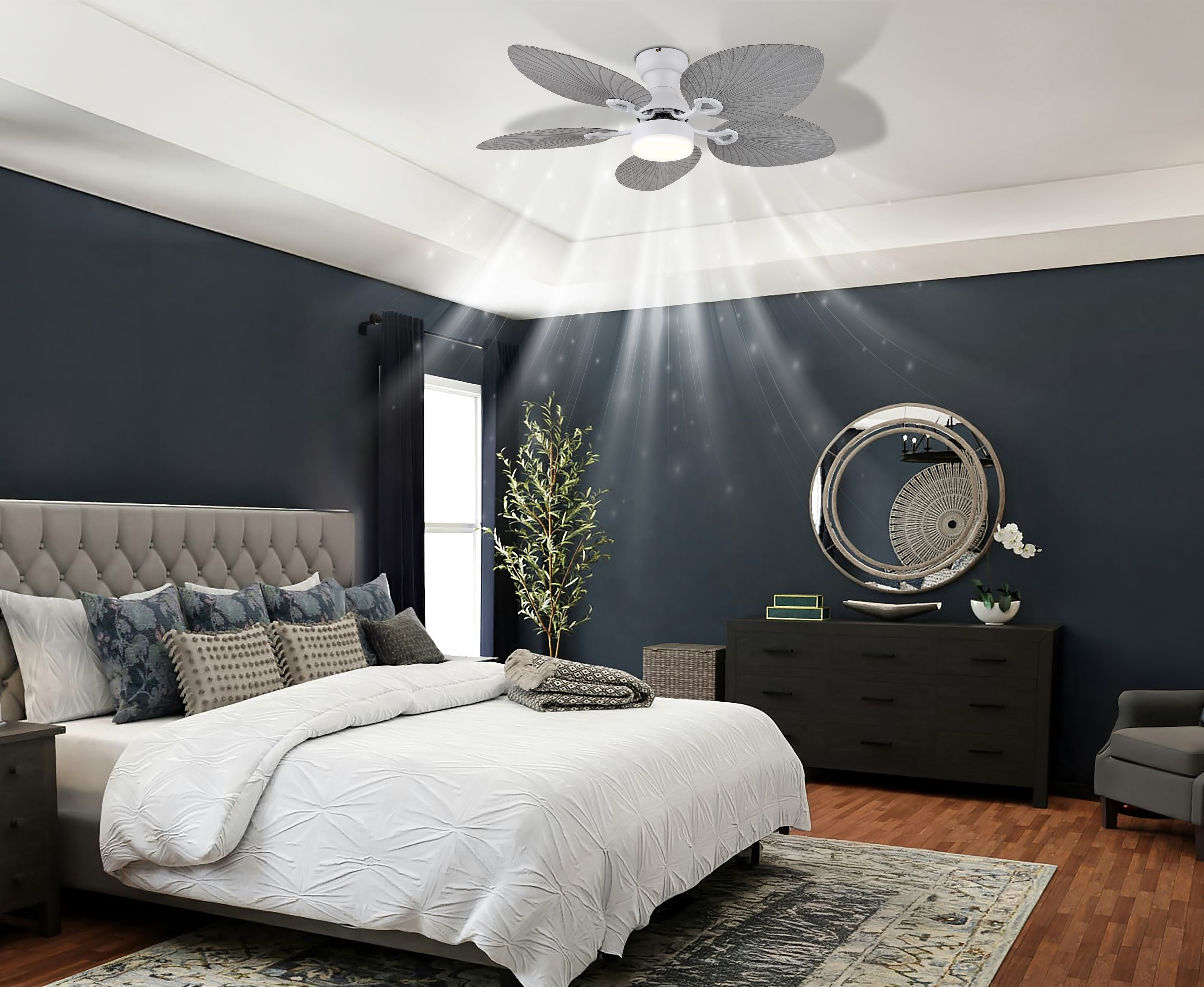 Schlafzimmer mit Deckenventilator, Bett, Kommode und Sessel. Dunkelblaue Wände, weiße Decke und Holzboden.