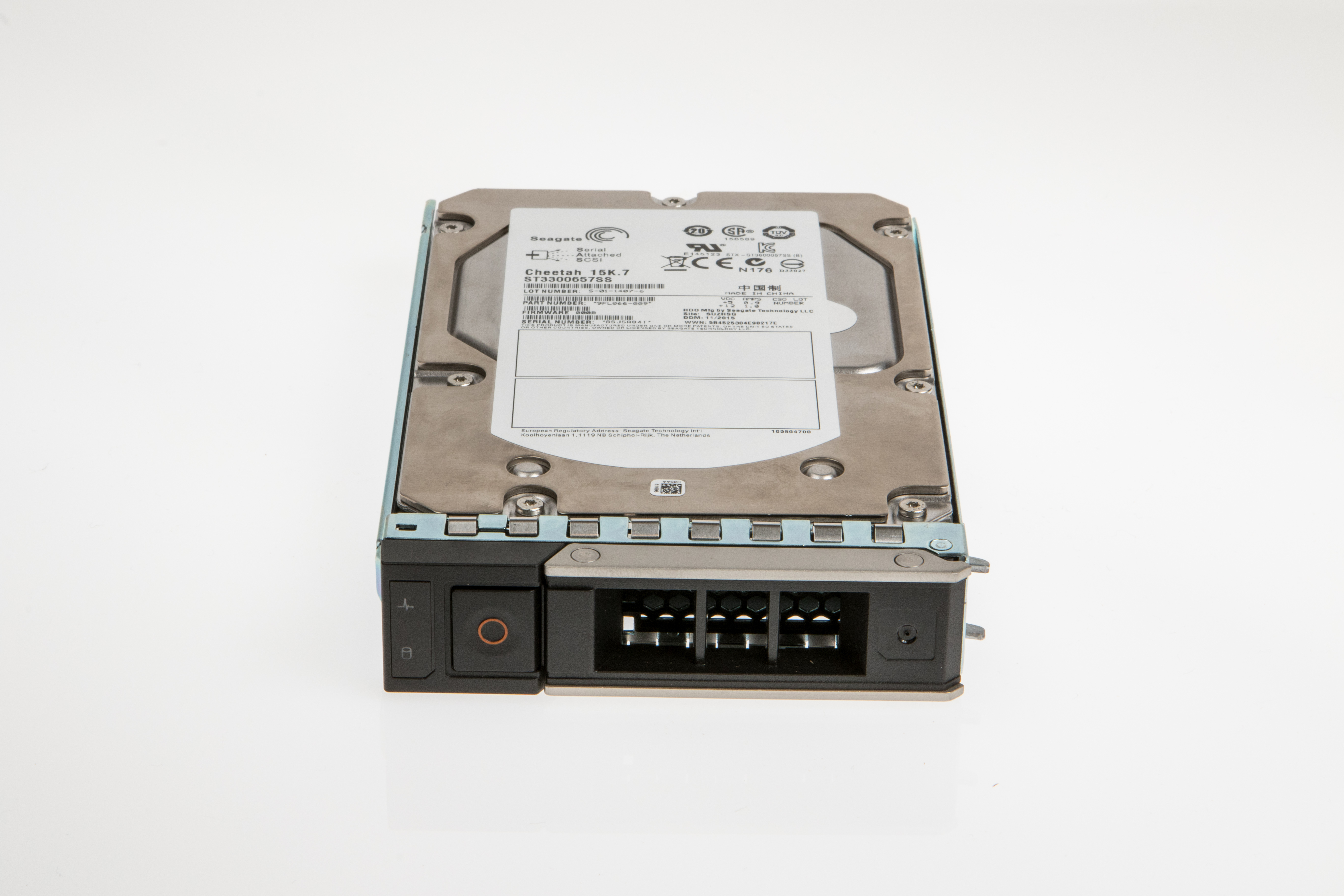 Un disco rigido Seagate Cheetah argentato con pannello frontale nero ed etichetta. Poggia su una superficie bianca.