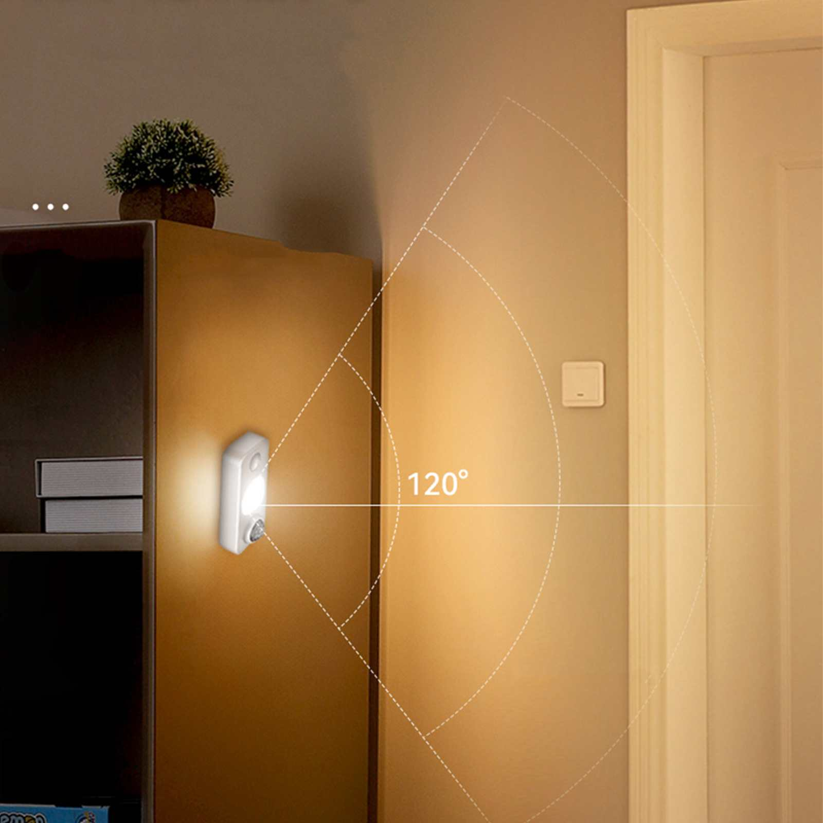 Ein Bewegungssensorlicht befindet sich an einem Holzschrank. Oben befindet sich eine Pflanze. Im Hintergrund sind eine Tür und ein Schalter.
