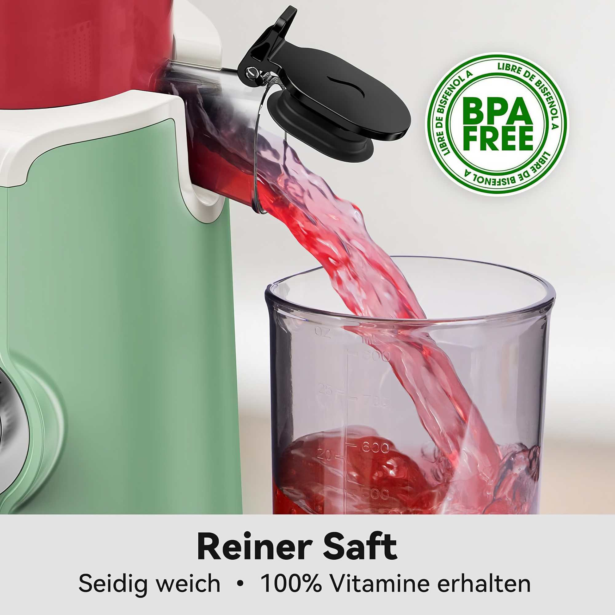 Ein Entsafter gießt roten Saft in einen transparenten Messbecher. Der Entsafter ist grün und rot. BPA-freies Etikett sichtbar.