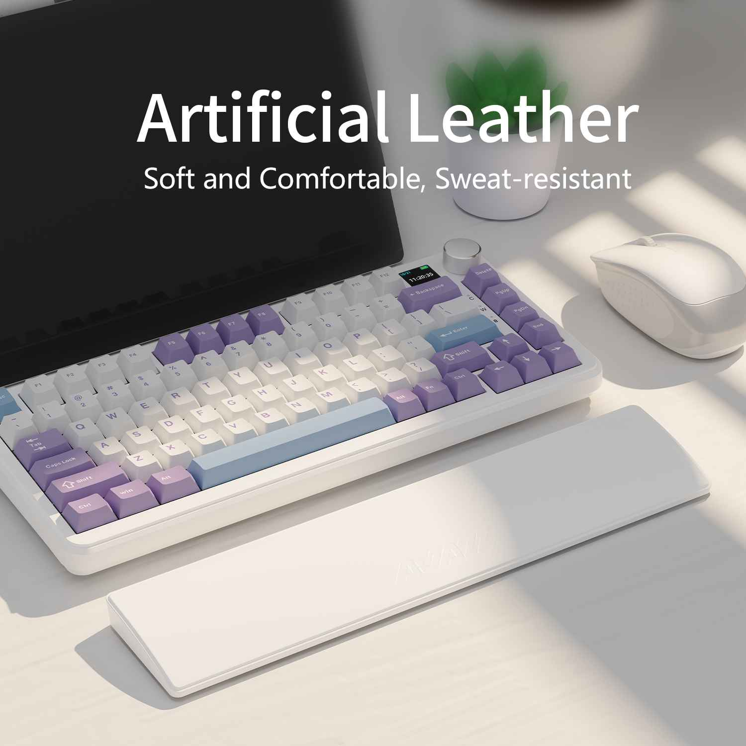 Eine weiße Tastatur mit lila Tasten und eine weiße Handgelenkauflage liegen auf einem Schreibtisch. Eine weiße Maus und eine grüne Pflanze sind ebenfalls vorhanden.