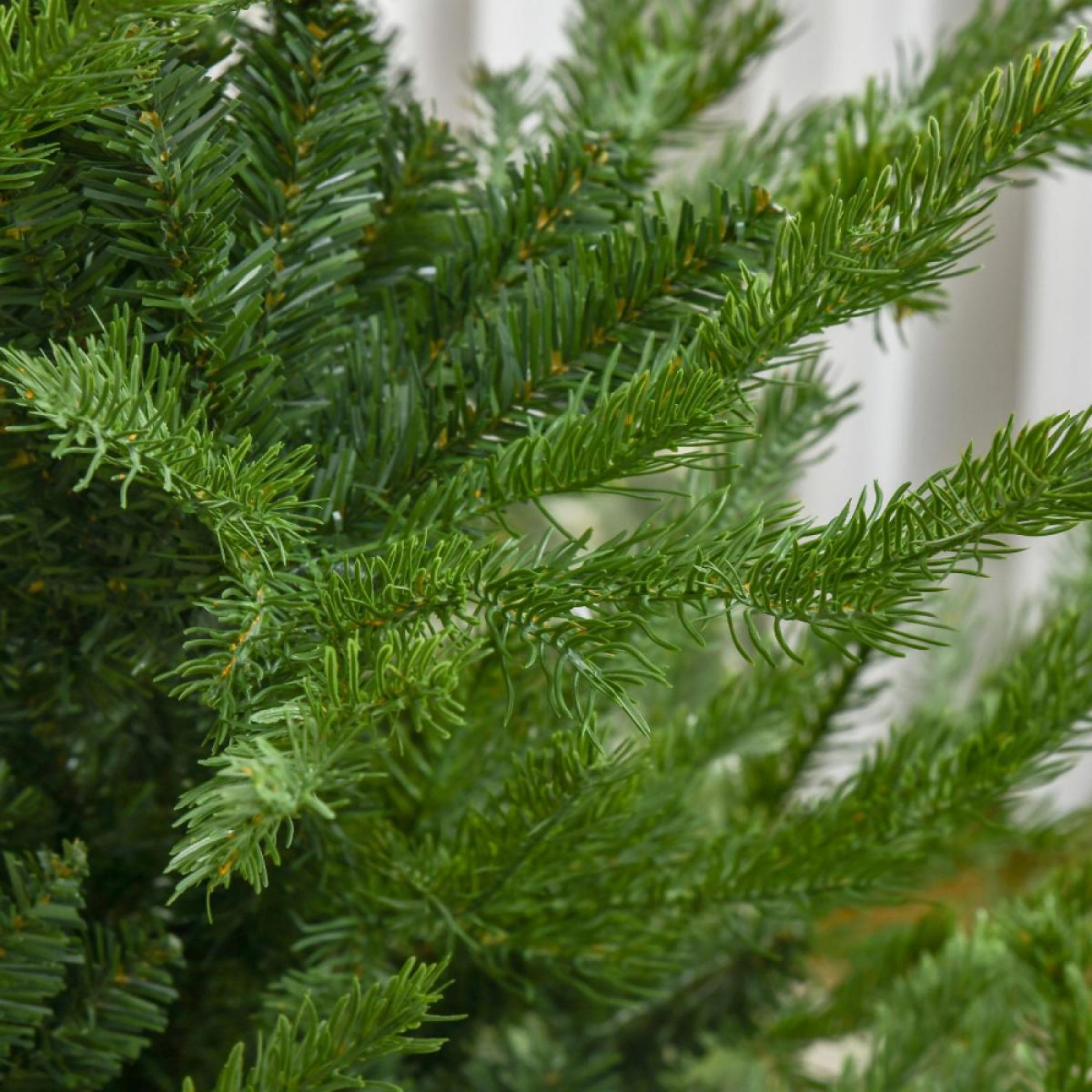 Nahaufnahme eines grünen künstlichen Weihnachtsbaums. Nadeln und Äste sind sichtbar.