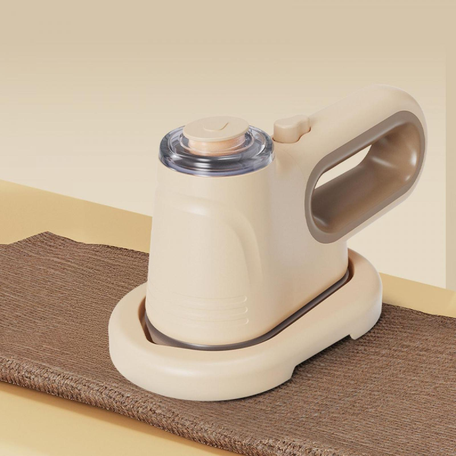 Ein cremefarbener Stoffrasierer auf einem braunen Stoff. Er hat eine klare Oberseite und einen Griff. Der Hintergrund ist beige.