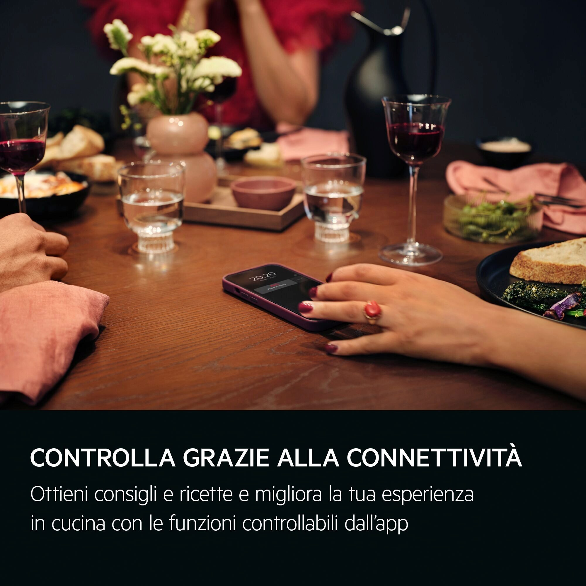 Stół jadalny z jedzeniem, napojami i telefonem z godziną 20:20. Ręka z pierścionkiem spoczywa na telefonie. Tekst: 'Food is ready'.