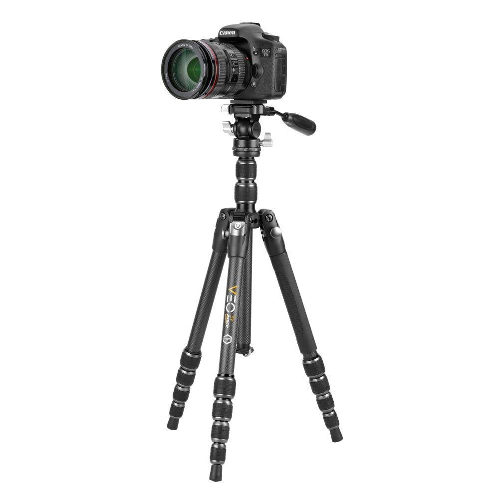 Una cámara Canon DSLR con lente está montada en un trípode negro y gris. La configuración está aislada sobre un fondo blanco.