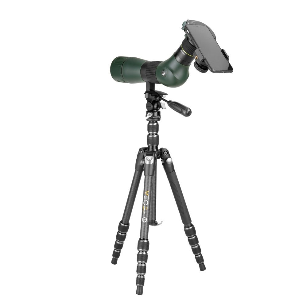 Un telescopio terrestre verde con un teléfono adjunto, montado en un trípode negro. El fondo es blanco.