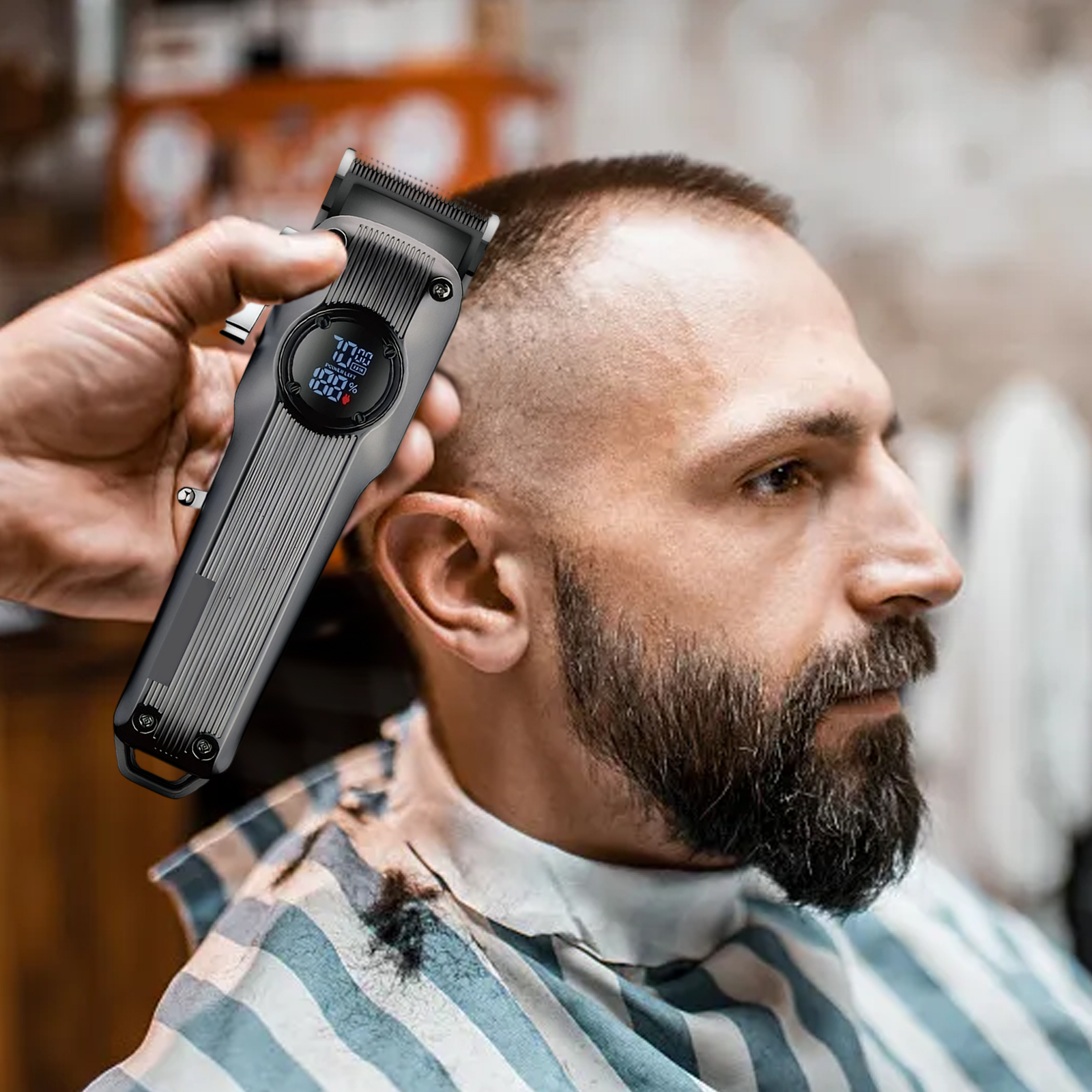 Ein Friseur rasiert das Haar eines Mannes mit einem Haarschneider. Der Haarschneider zeigt die Akkulaufzeit an. Der Mann hat einen Bart und trägt einen gestreiften Umhang.