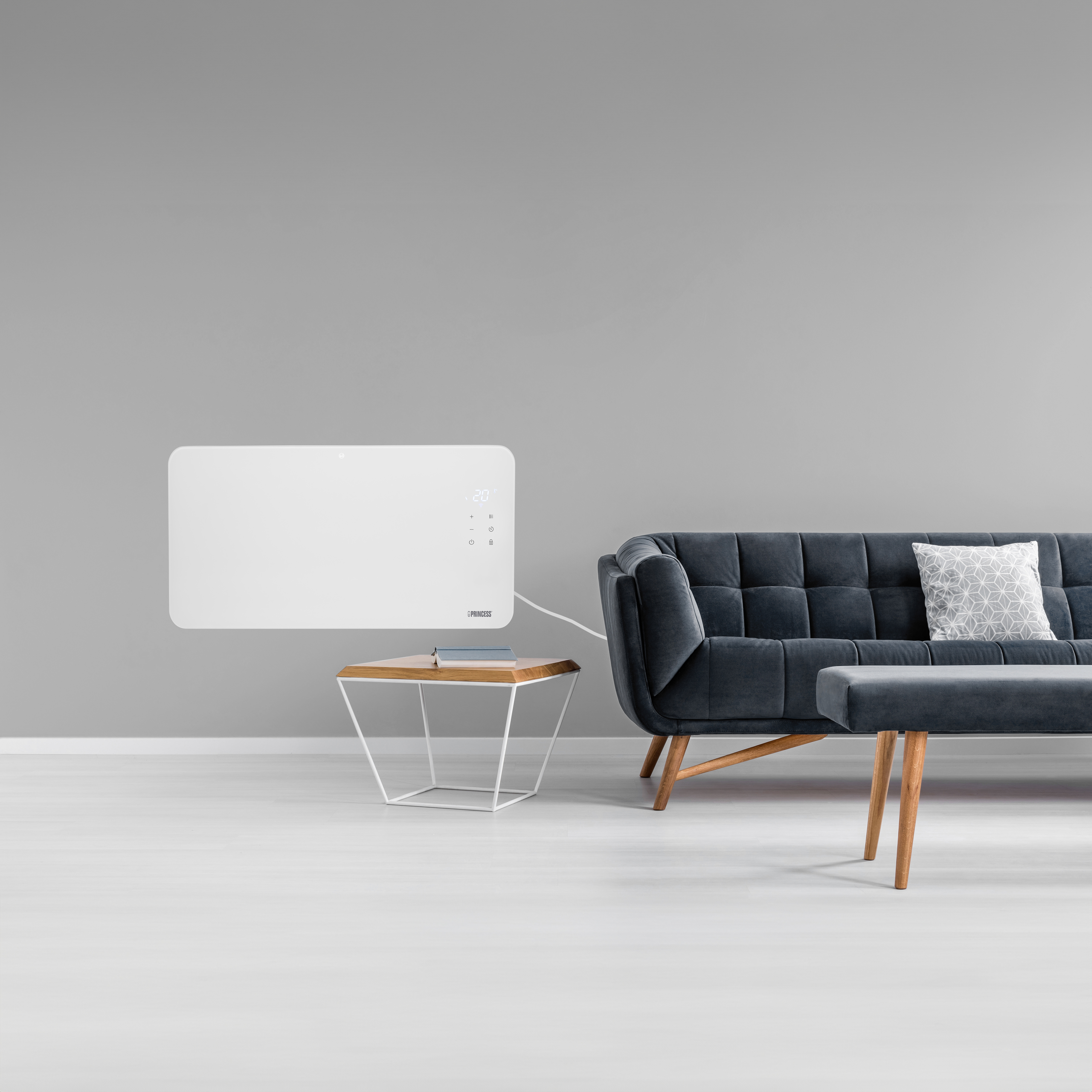 Een moderne woonkamer met een grijze muur, een witte verwarming en een donkergrijze bank met een bank. Een bijzettafel staat voor de bank.