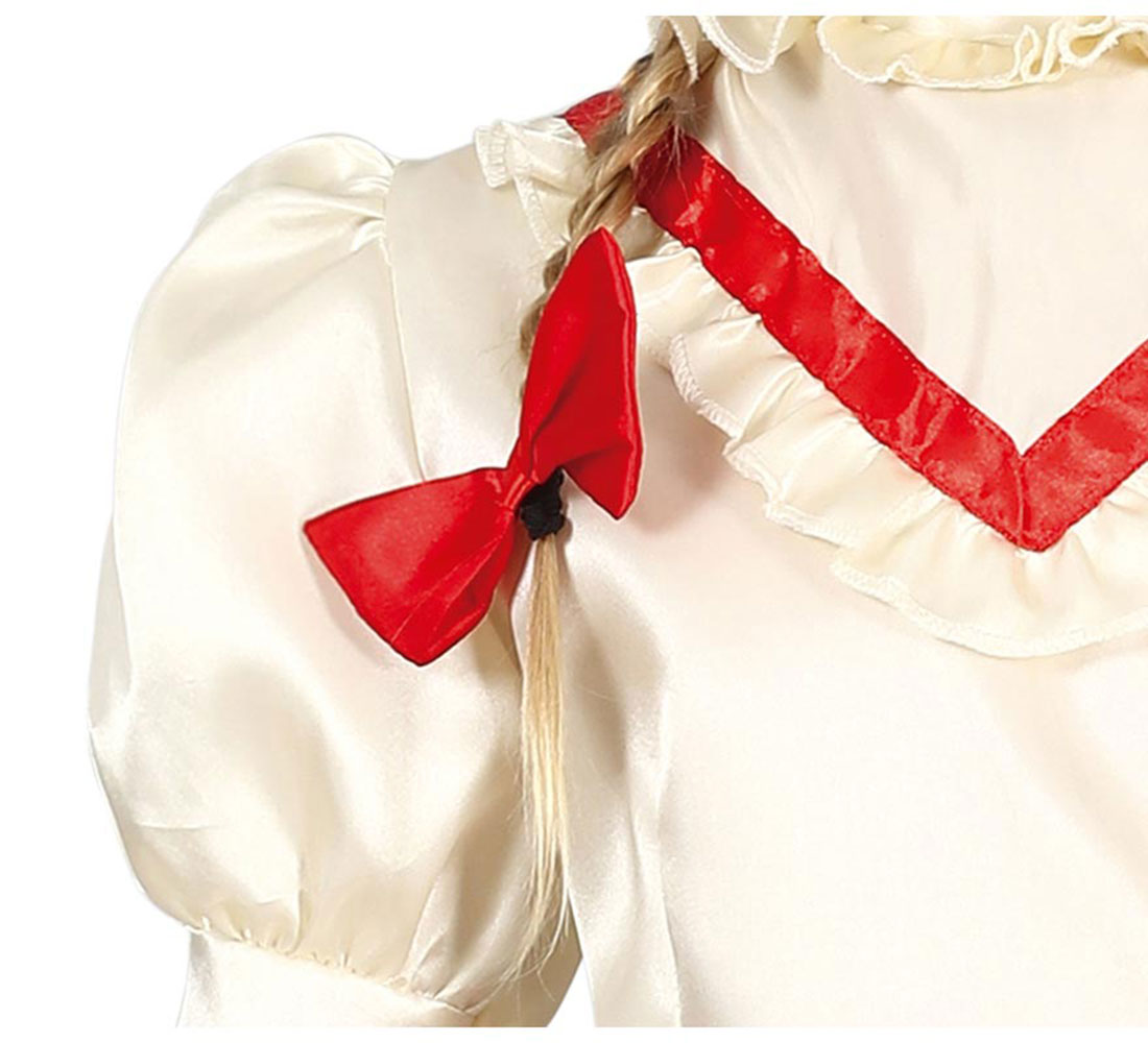 Primer plano de un vestido color crema con un lazo rojo en una trenza. El vestido tiene un ribete rojo y un cuello con volantes.