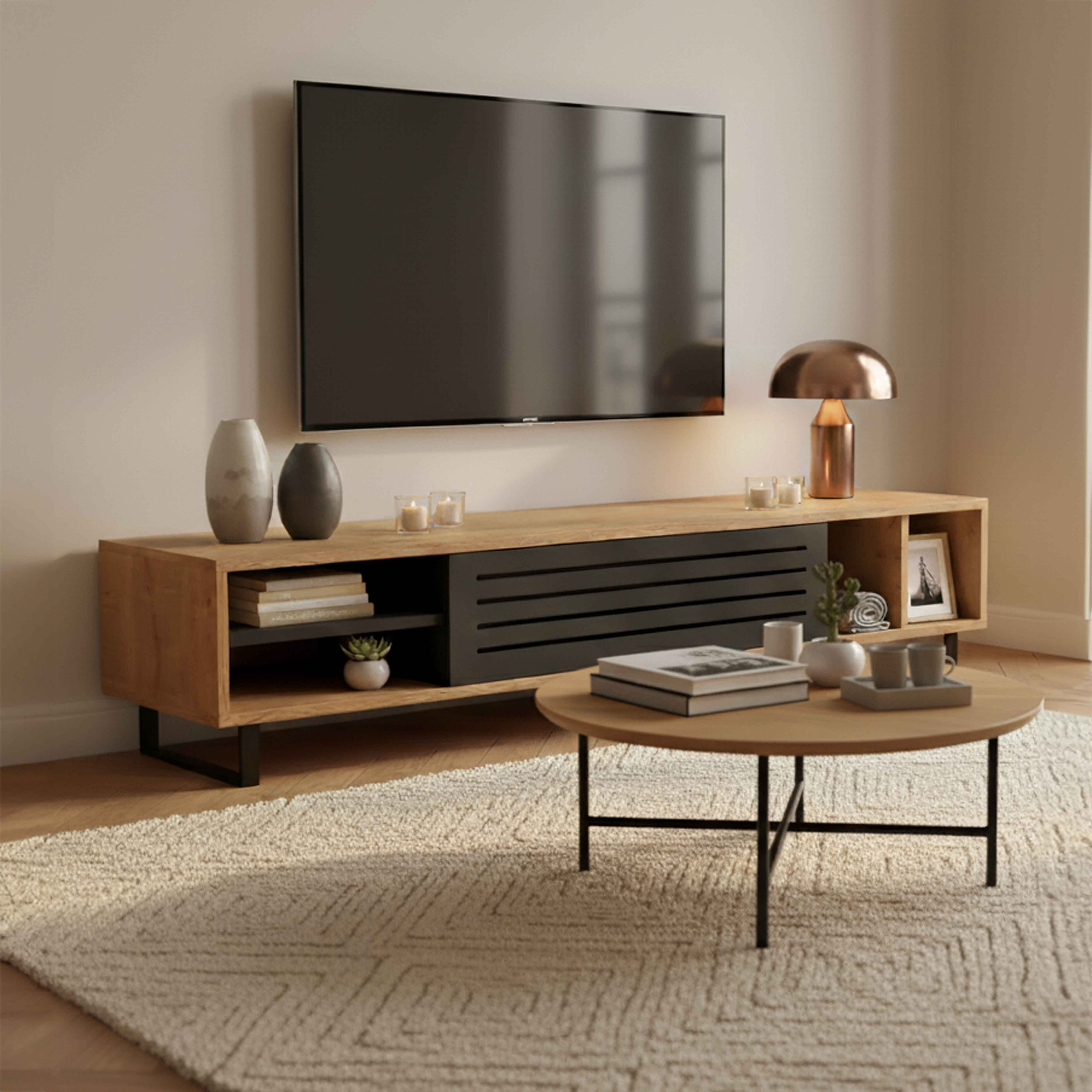 Ein Wohnzimmer mit Fernseher auf einem Holzschrank, einem Couchtisch und einem Teppich. Dekorative Elemente sind sichtbar.