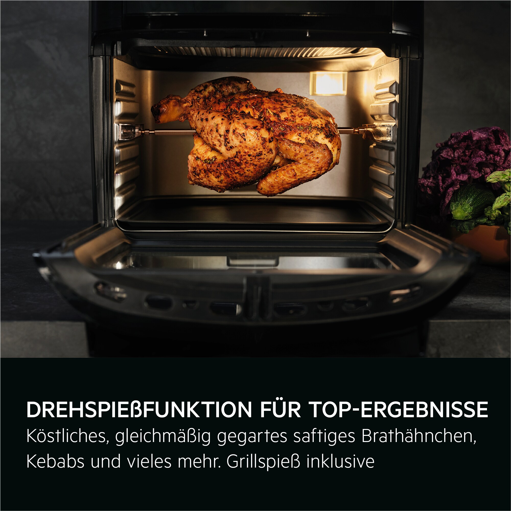 Ein Brathähnchen befindet sich im Ofen. Dunkler Hintergrund. Gemüse rechts.