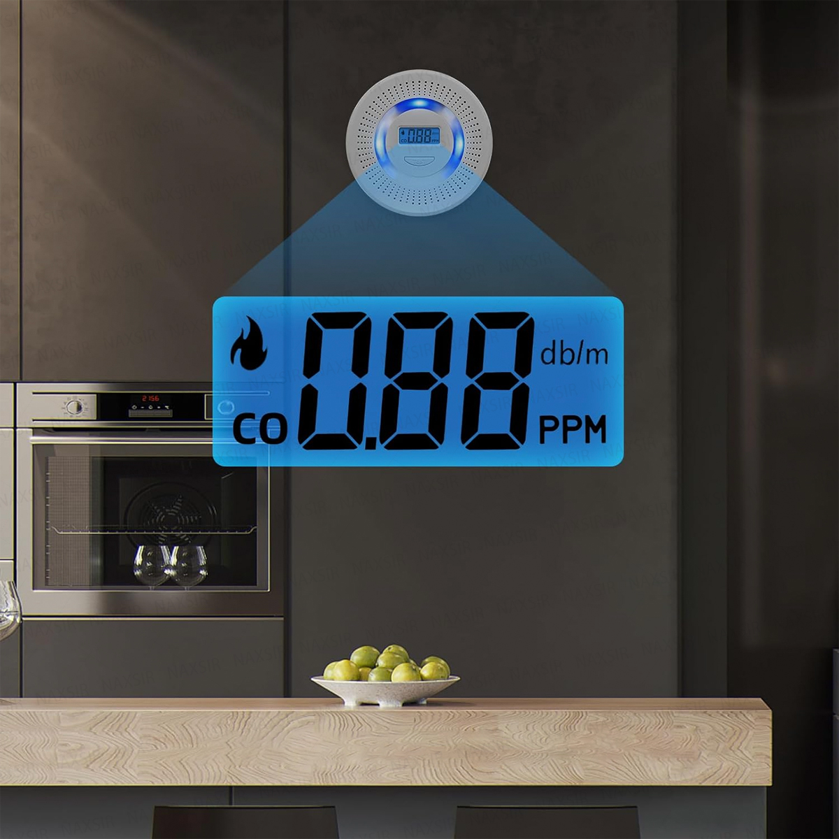 Eine Küchenszene mit einem Gasdetektor, der 0,88 ppm anzeigt. Auf einer Holztheke steht eine Schüssel mit grünen Äpfeln, im Hintergrund ein Ofen.