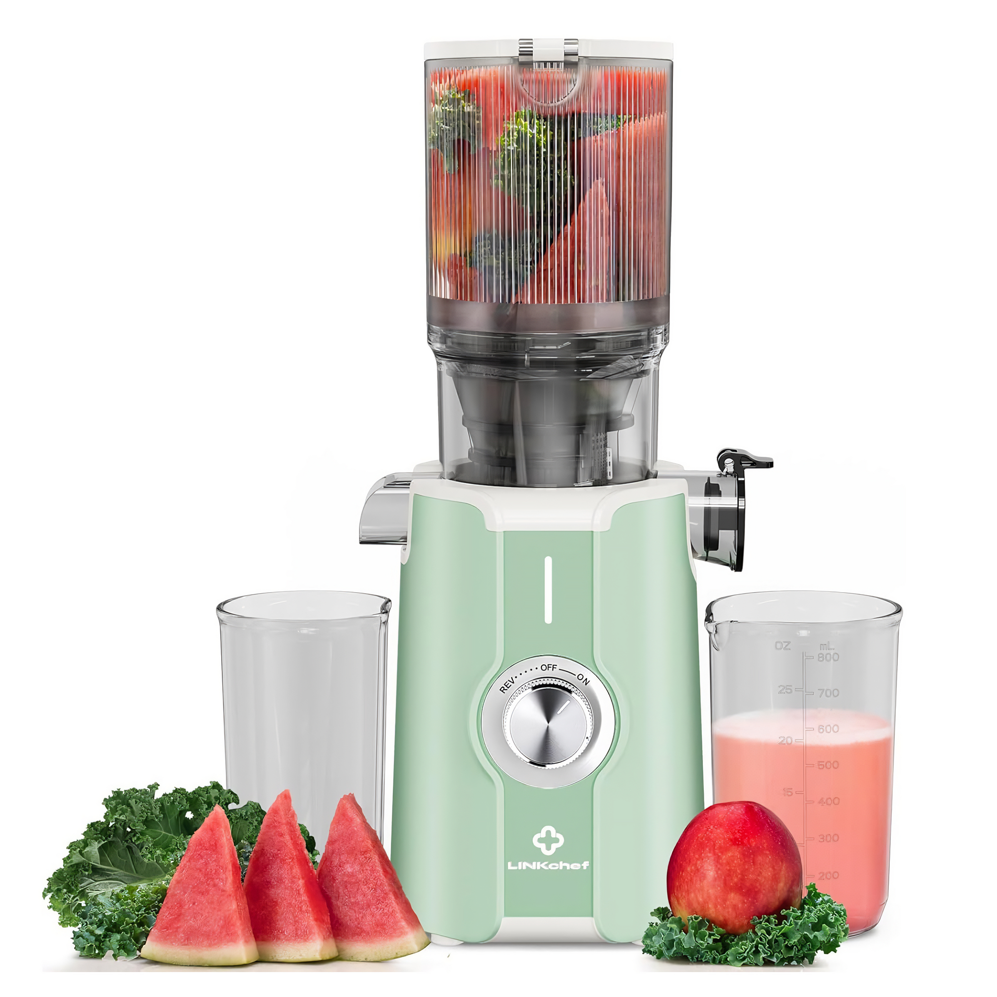 Ein Entsafter mit Wassermelone, Grünkohl und einem Glas mit Saft. Rechts ist ein roter Apfel mit Grünkohl.