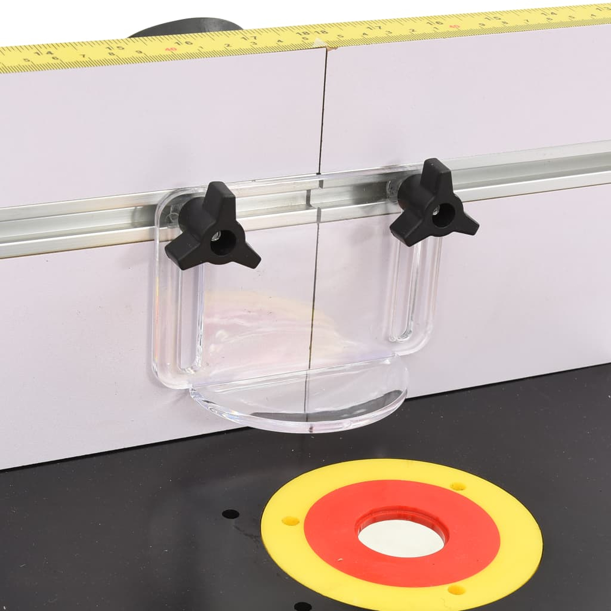 Eine Holzbearbeitungsmaschine mit gelb-rotem Ring, durchsichtigem Kunststoffschutz, schwarzen Knöpfen und einem Maßband.