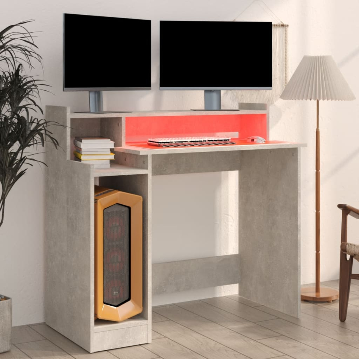 Ein Computertisch mit zwei Monitoren, einer Tastatur und einem Computer-Tower. Eine Lampe und eine Pflanze sind ebenfalls sichtbar.