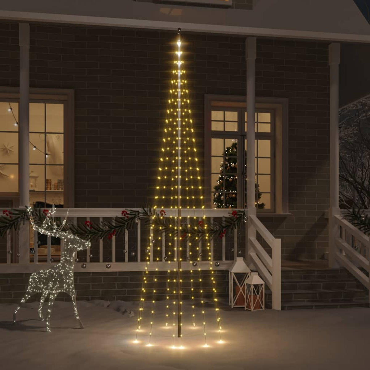 Ein mit Weihnachten dekoriertes Haus. Vorne steht ein beleuchteter Baum. Eine Rentierdekoration und beleuchtete Laternen sind ebenfalls zu sehen.