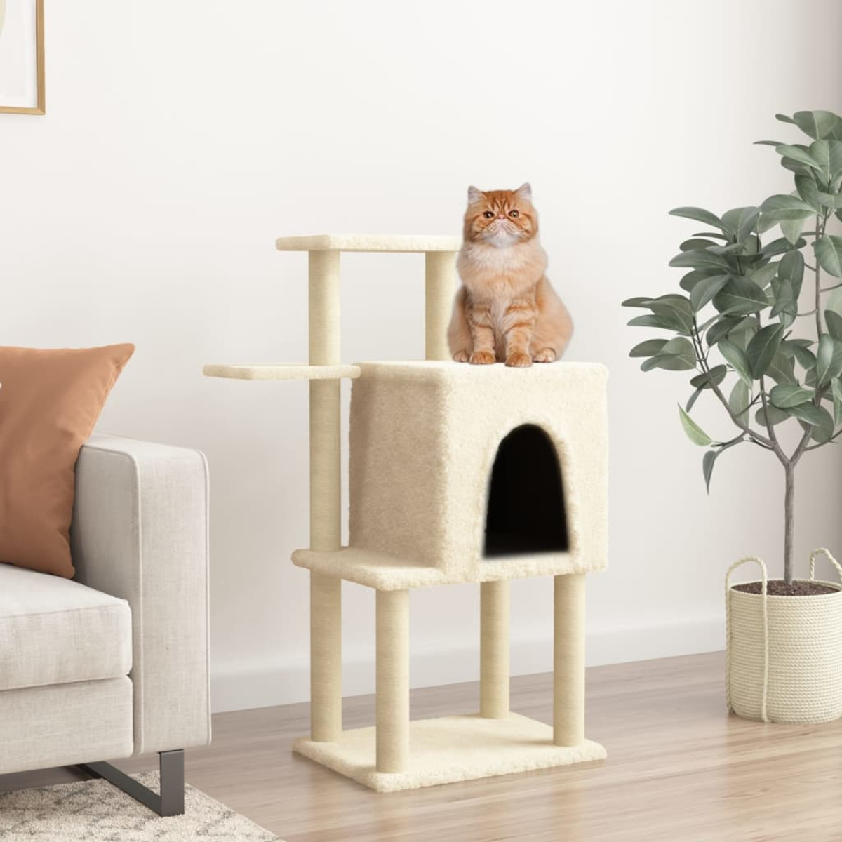 Eine rot getigerte Katze sitzt auf einem beigen Kratzbaum mit hausförmiger Öffnung. Im Hintergrund sind ein Sofa und eine Pflanze.