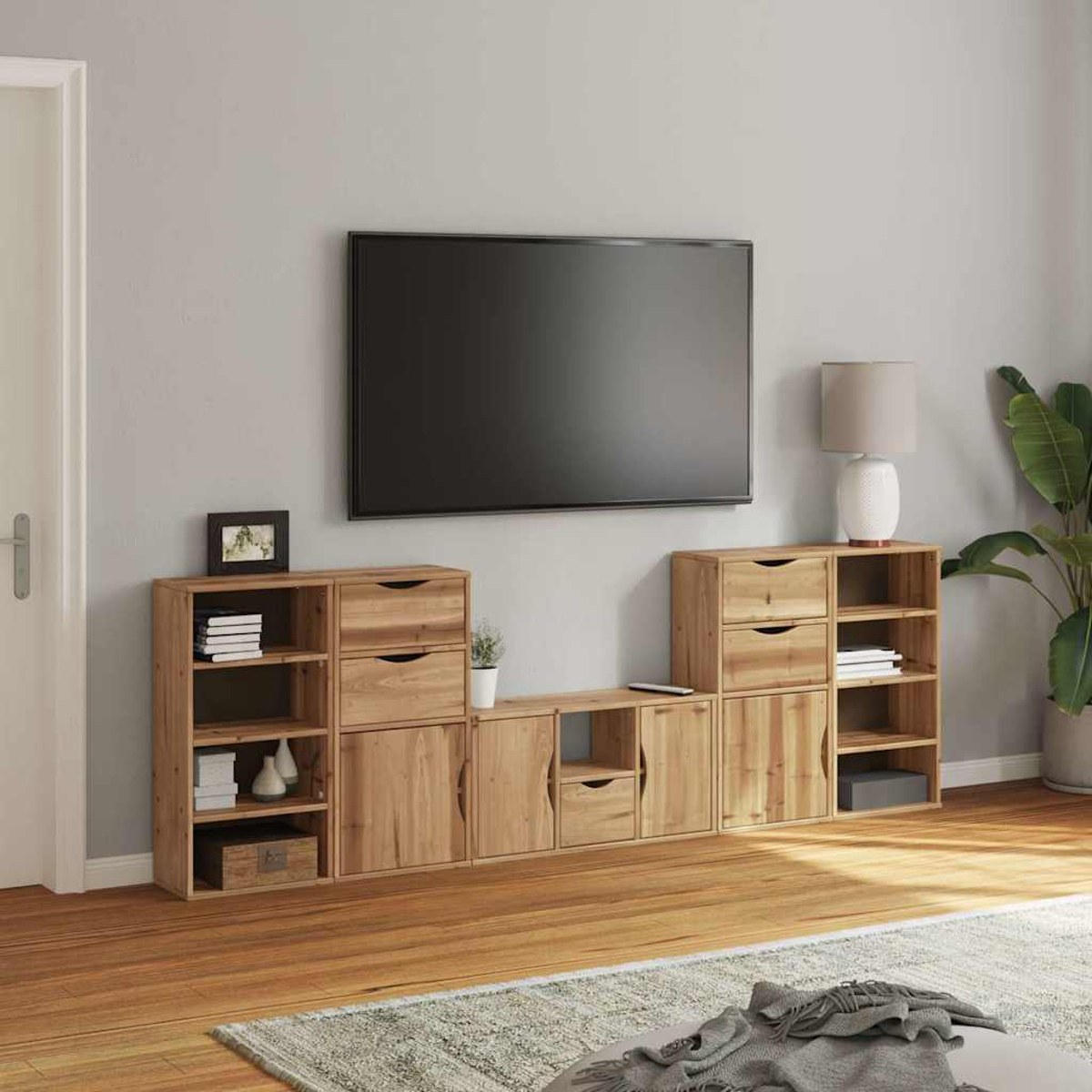 Wohnzimmer mit Holzmöbeln, großem Fernseher, Lampe und Pflanze. Heller Holzboden und grauer Teppich im Vordergrund.