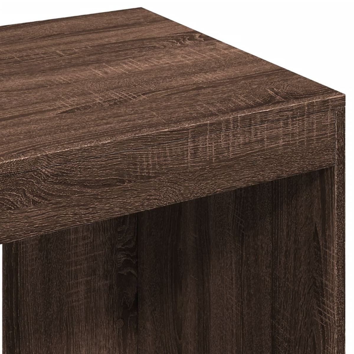 Nahaufnahme eines braunen Holztisches. Die Ecke des Tisches zeigt eine strukturierte Oberfläche mit sichtbarer Holzmaserung.
