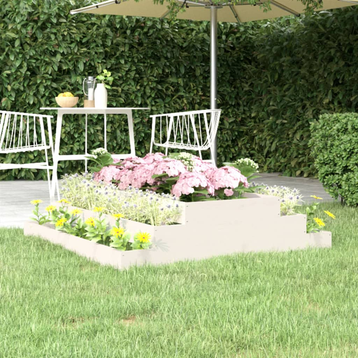 Gartenszene mit weißem Tisch und Stühlen, rosa und gelben Blumen in einem Hochbeet. Ein großer Sonnenschirm spendet Schatten.