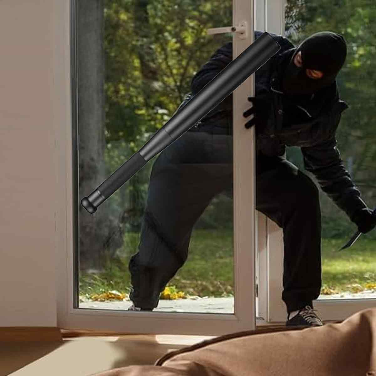 Ein maskierter Mann mit Baseballschläger und Messer bricht in ein Haus ein. Er ist schwarz gekleidet. Eine braune Decke ist im Vordergrund.