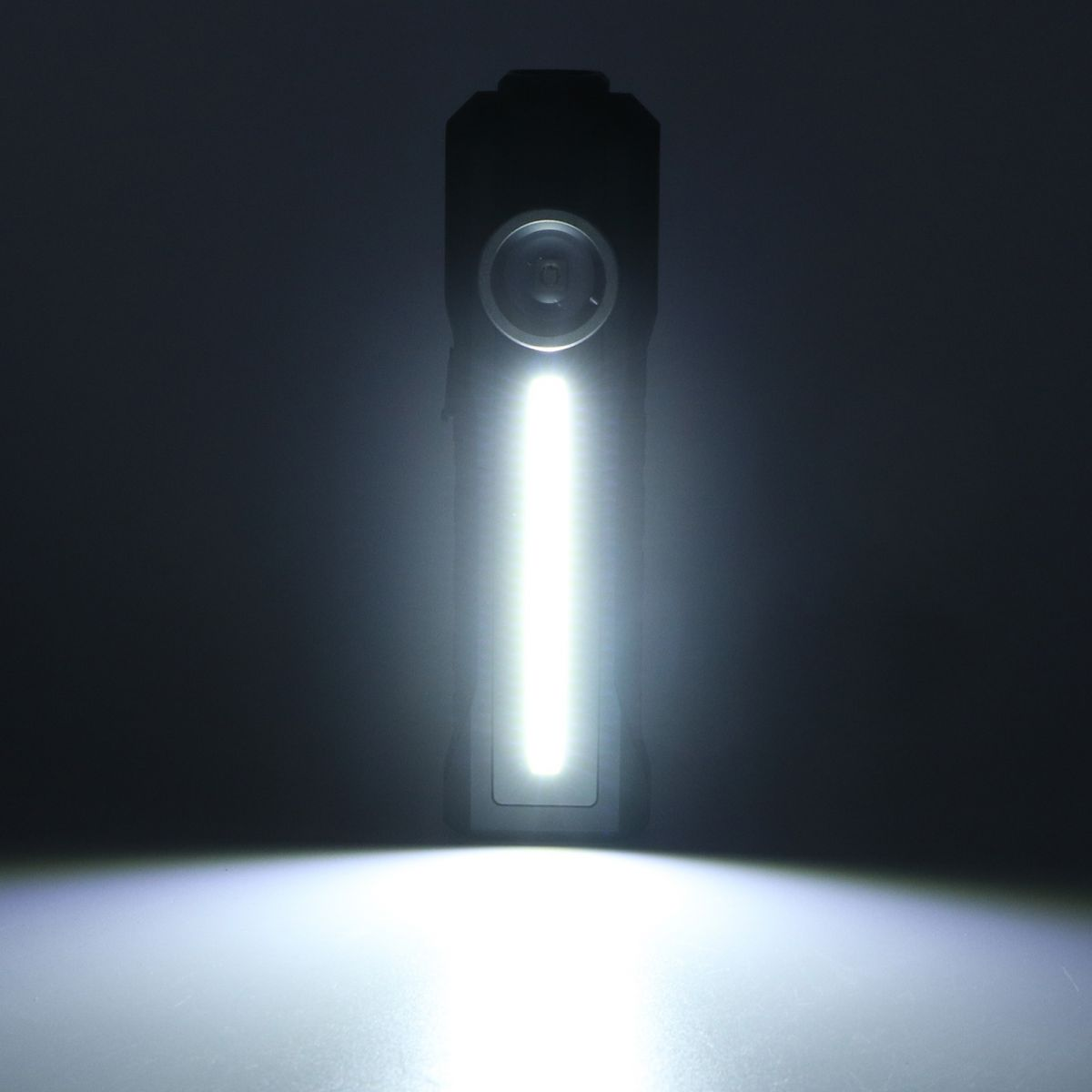 Eine Taschenlampe ist eingeschaltet und beleuchtet einen dunklen Raum. Das Licht ist hellweiß und wirft einen starken Strahl.