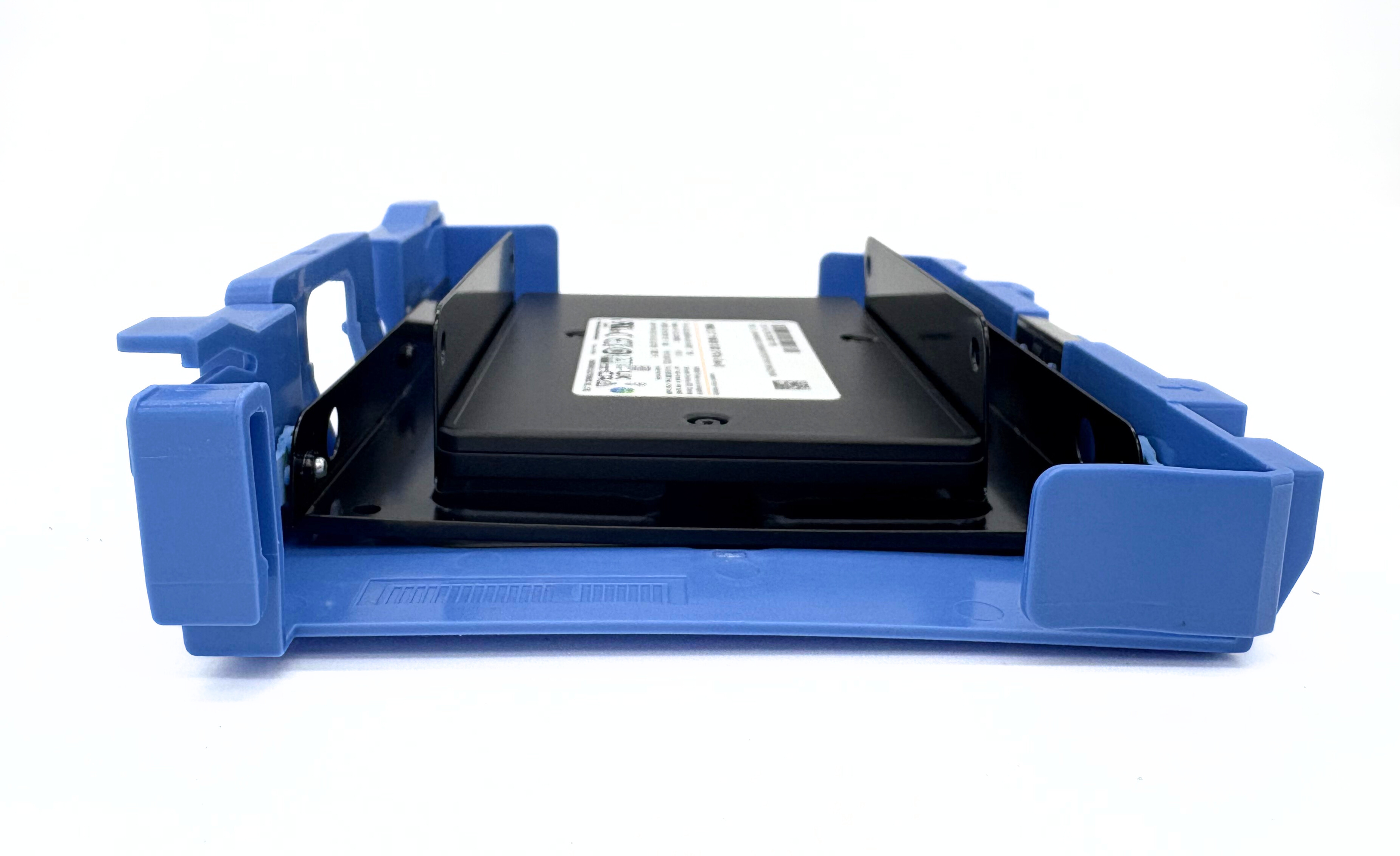 Un disco rigido nero è tenuto all'interno di un vassoio di plastica blu. Lo sfondo è bianco.
