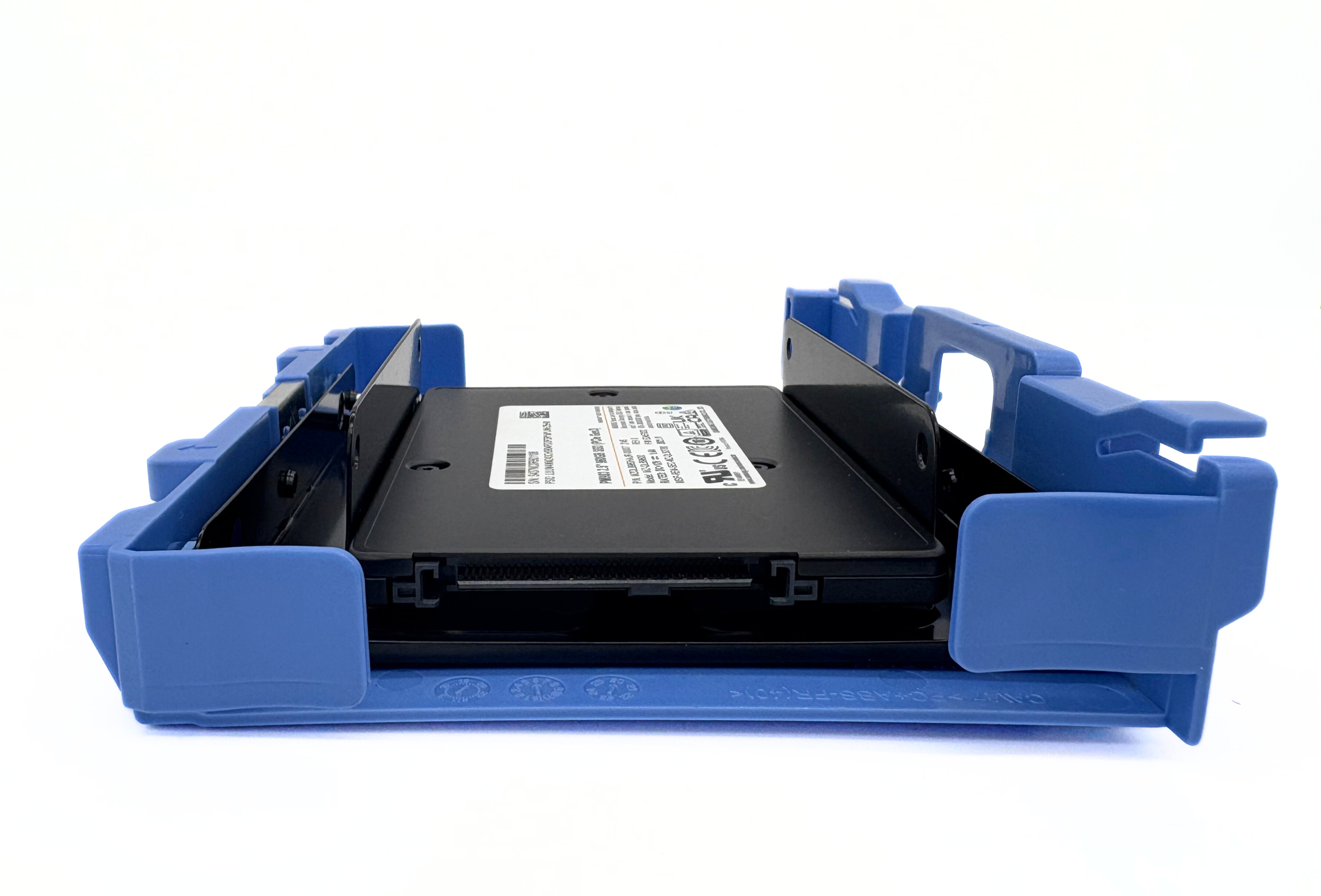 Un disco rigido nero è tenuto all'interno di un involucro di plastica blu su sfondo bianco.