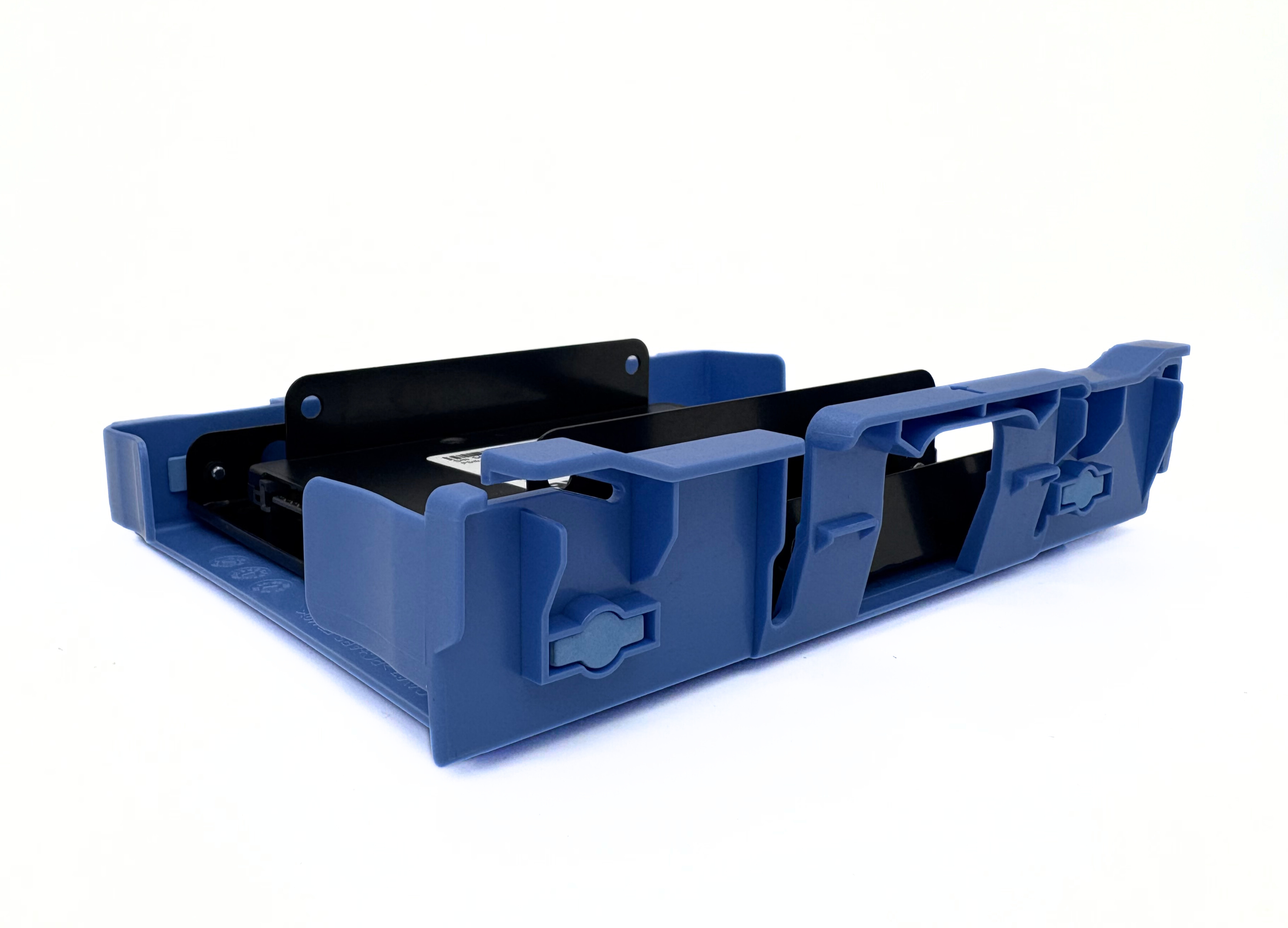 Un componente in plastica blu e nera, forse per l'elettronica, è su una superficie bianca. L'oggetto ha creste e fessure.