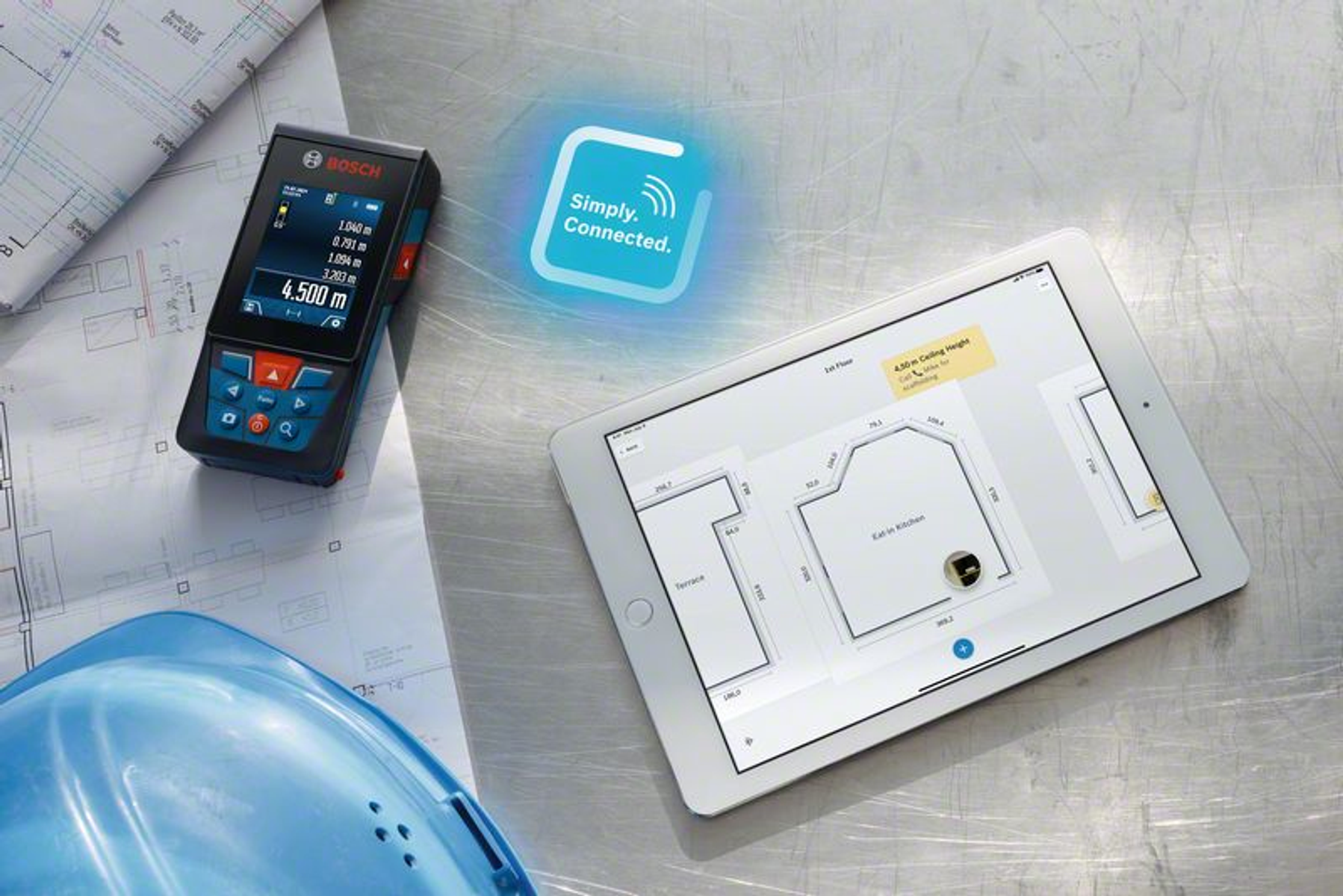 Un misuratore laser Bosch accanto a un tablet che mostra una planimetria. Un casco blu e progetti completano la scena.