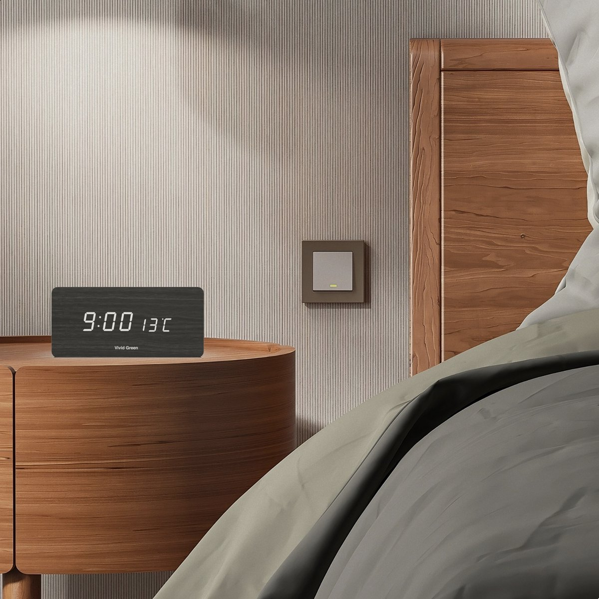 A wooden bedside table holds a digital clock. The time is 9:00 and temperature is 13C. A light switch and a bed are also visible.