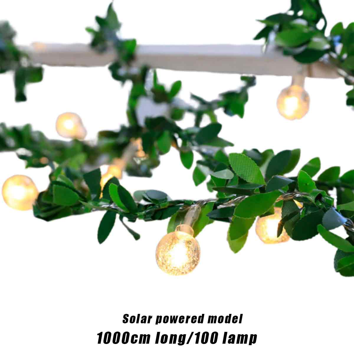 Lichterkette mit grünen Blättern und kleinen, leuchtenden Glühbirnen. Text unten: Solarbetriebenes Modell 1000cm lang/100 Lampe.