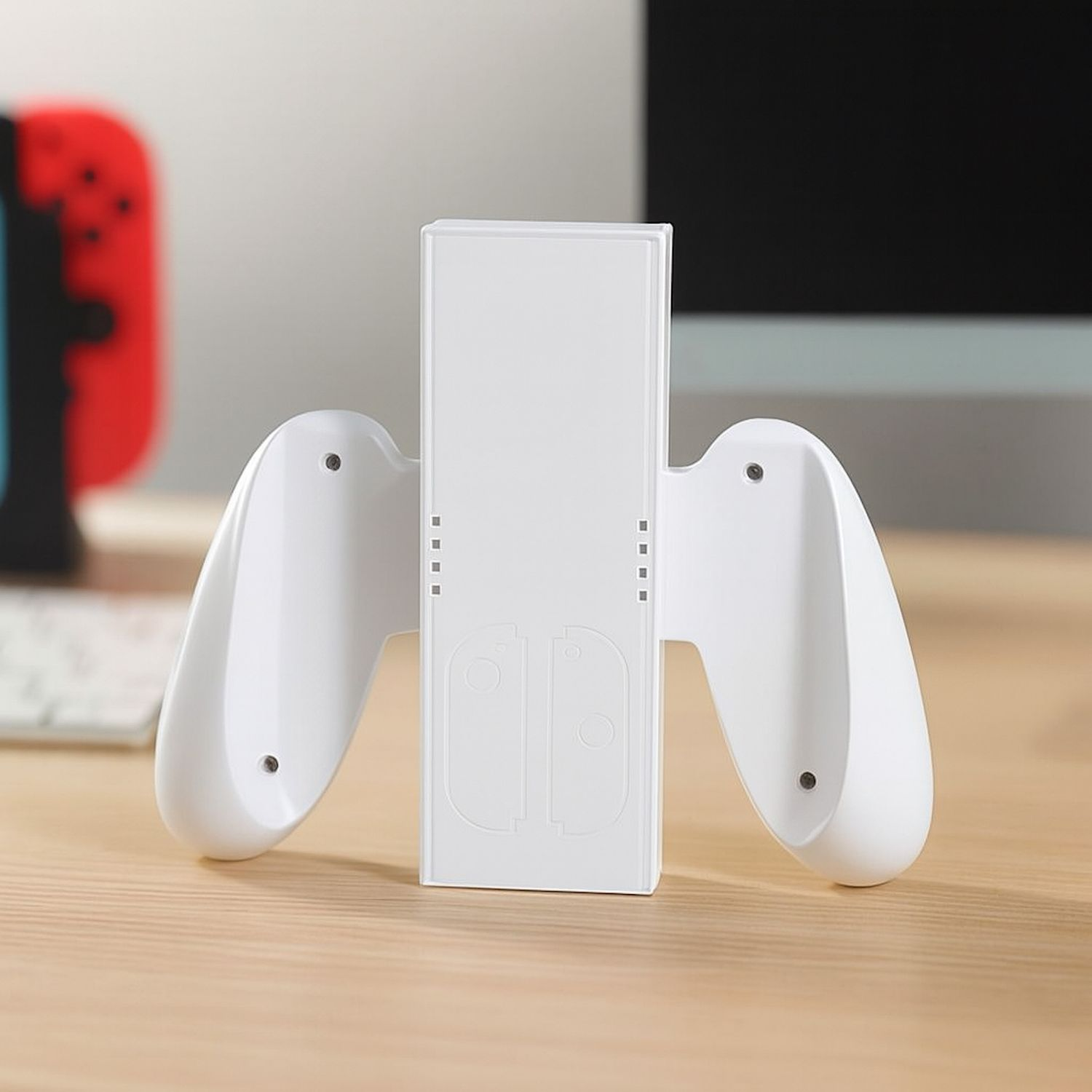 Weißes Nintendo Switch-Dock mit befestigten Joy-Con-Controllern auf einem Holzschreibtisch.