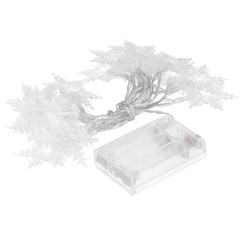 Schnur aus Schneeflockenlichtern, aufgerollt, mit einem durchsichtigen Batteriefach auf weißem Hintergrund.