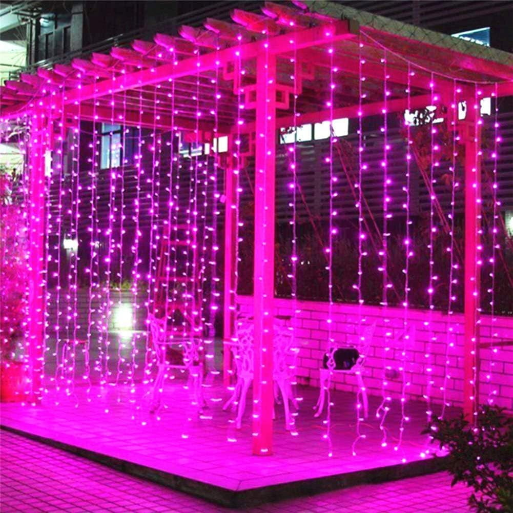 Ein rosa Pavillon, der mit Lichterketten geschmückt ist. Im Inneren befinden sich weiße Stühle und ein Tisch. Pflanzen sind im Hintergrund sichtbar.