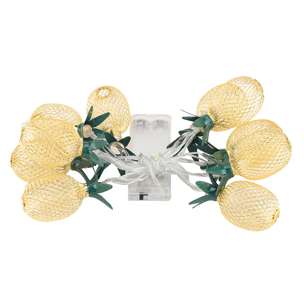 Eine Lichterkette mit goldenen Ananas, grünen Stielen und einem transparenten Akkupack vor weißem Hintergrund.