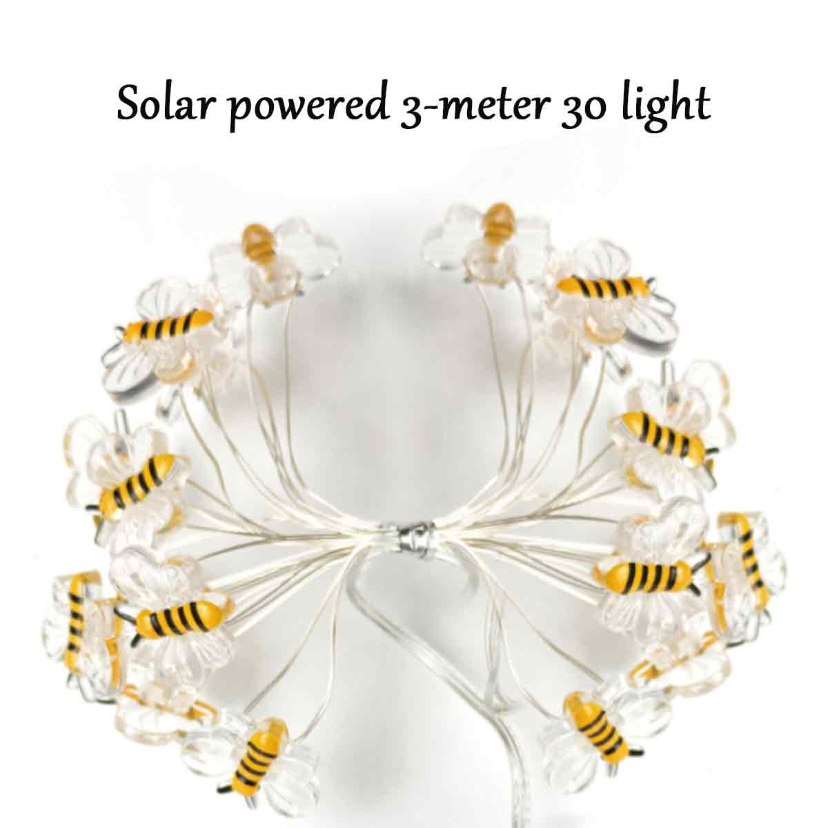 Lichterkette mit bienenförmigen Dekorationen. Gelbe und schwarze Bienendesigns an klaren blütenförmigen Lichtern.