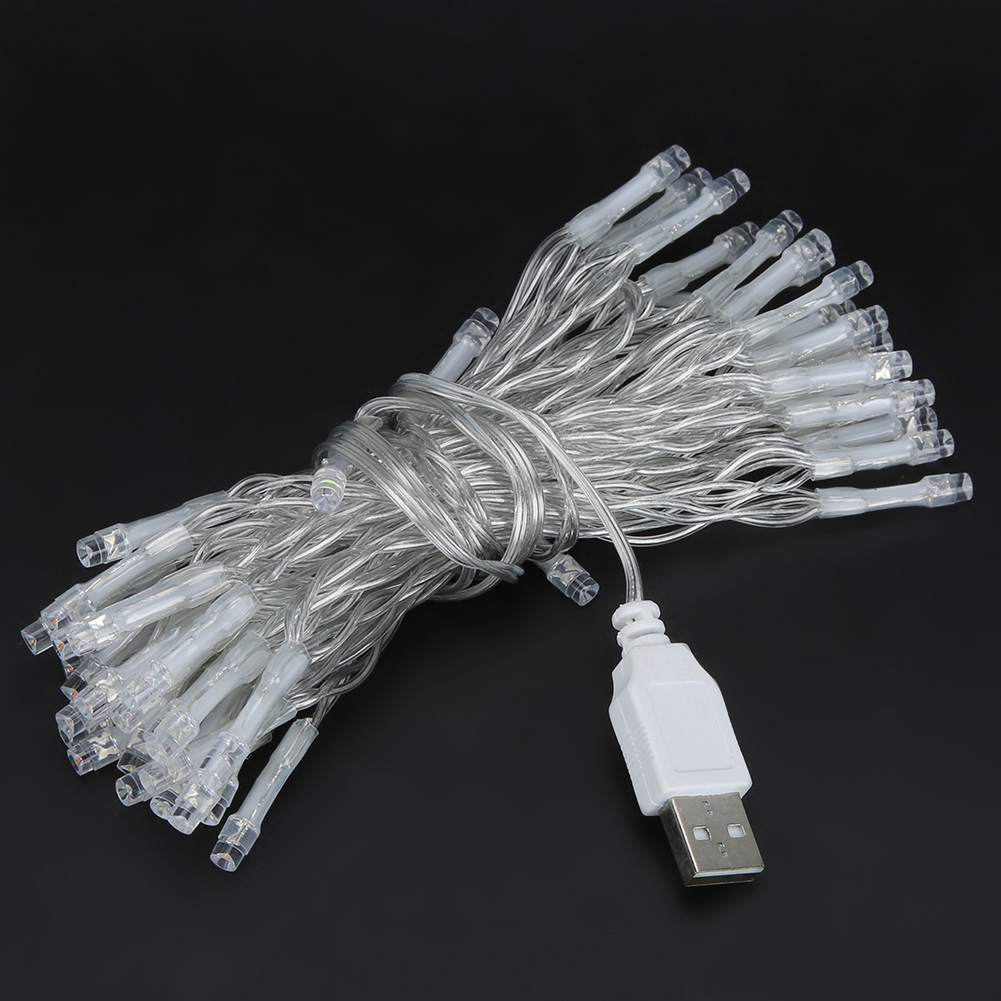 Eine Schnur aus kleinen LED-Leuchten, zusammengebunden mit einem USB-Stecker, auf einer schwarzen Oberfläche. Die Lichter sind klar, und der Draht ist silber.