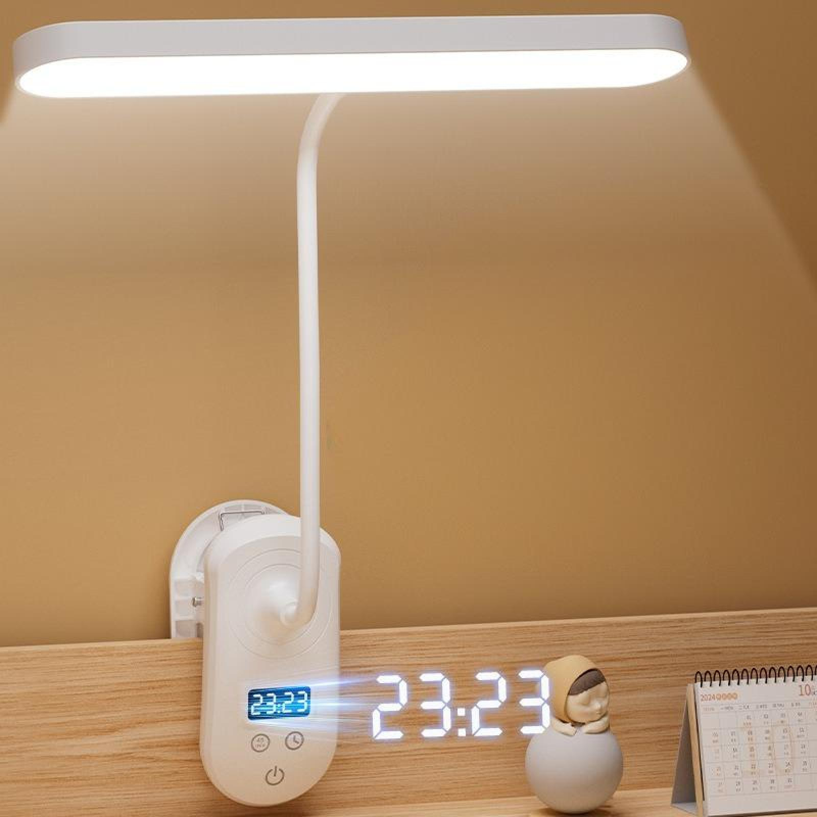 Eine weiße Schreibtischlampe mit Digitaluhr, die 23:23 anzeigt. Eine kleine Figur und ein Kalender sind ebenfalls vorhanden.