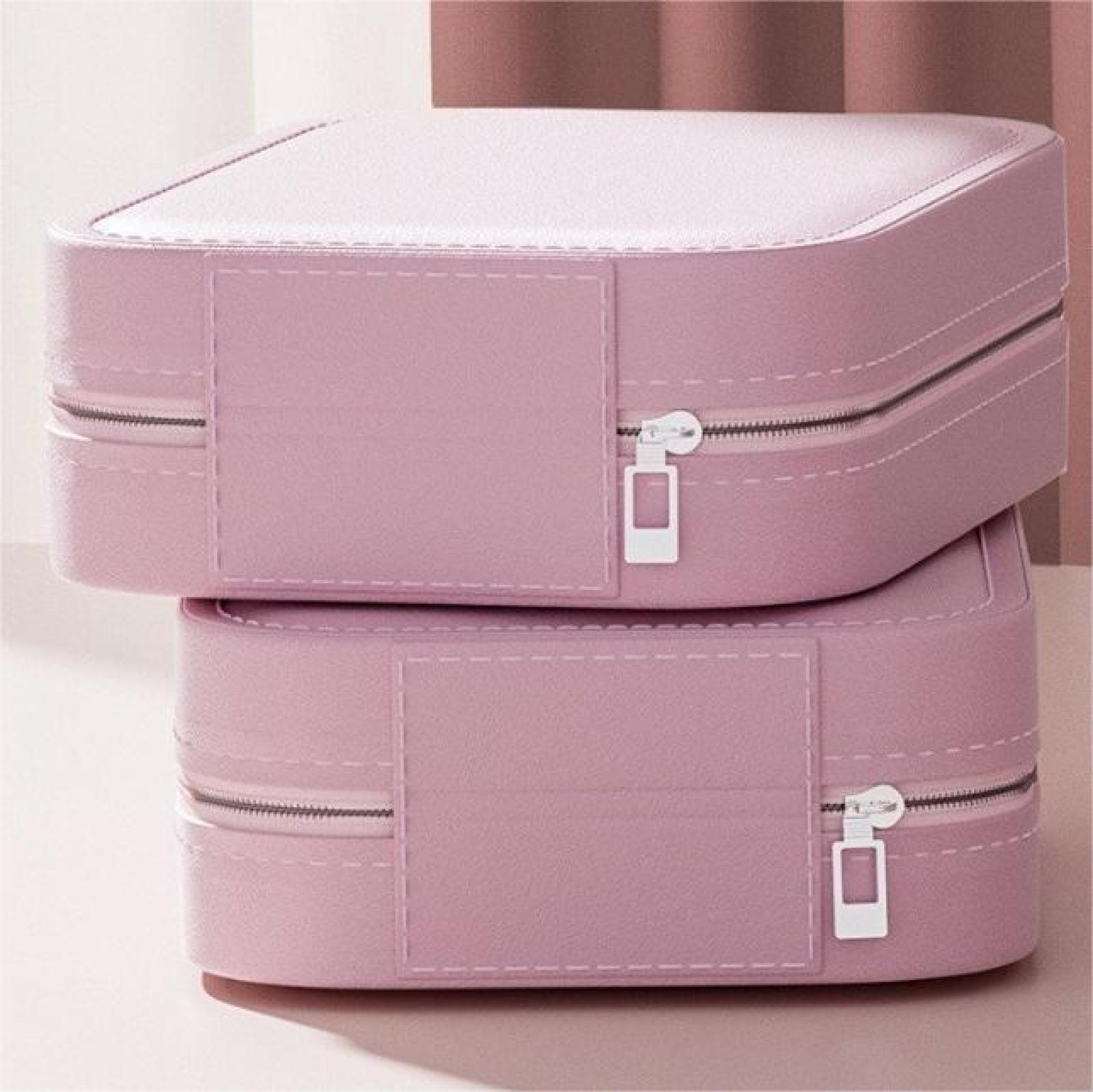 Zwei gestapelte, rosa Schmuckkästchen mit Reißverschlüssen und Nahtdetails. Der Hintergrund ist zartrosa und weiß.