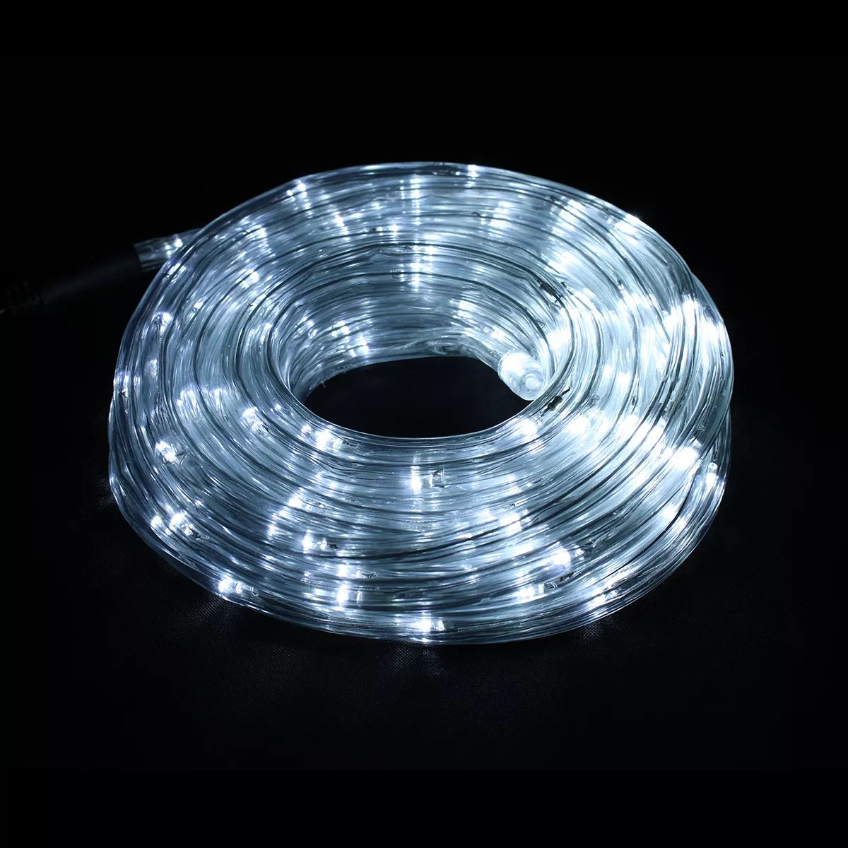 Eine aufgerollte Schnur aus weißen LED-Leuchten. Die Lichter sind in einem durchsichtigen Kunststoffschlauch eingeschlossen. Der Hintergrund ist schwarz.
