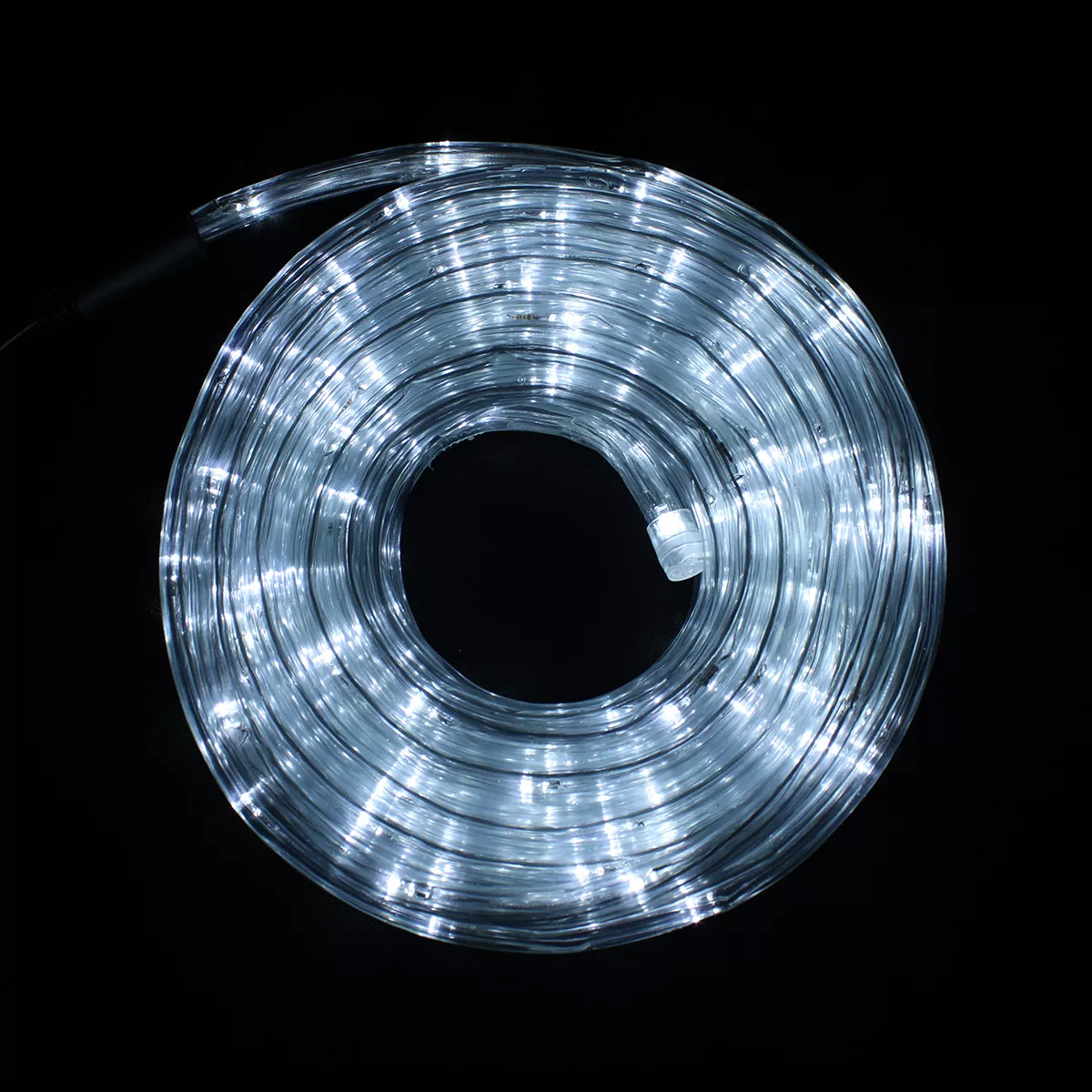 Eine aufgerollte Schnur aus weißen LED-Leuchten vor einem schwarzen Hintergrund. Die Lichter sind hell und gleichmäßig verteilt.
