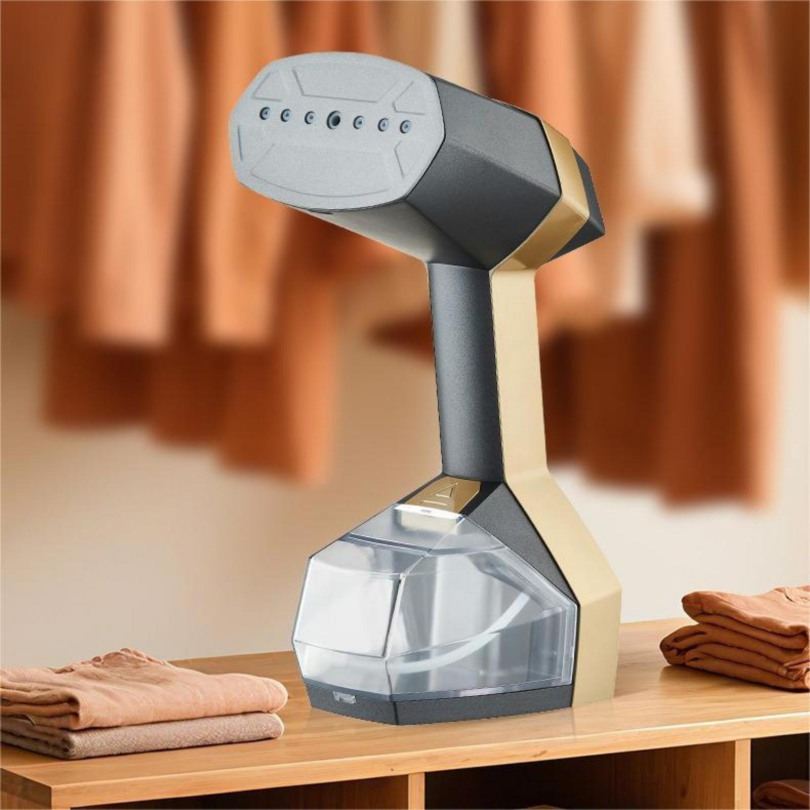 Ein schwarz-goldener Kleiderdampfer auf einem Holztisch neben gefalteter Kleidung. Der Hintergrund ist verschwommen.