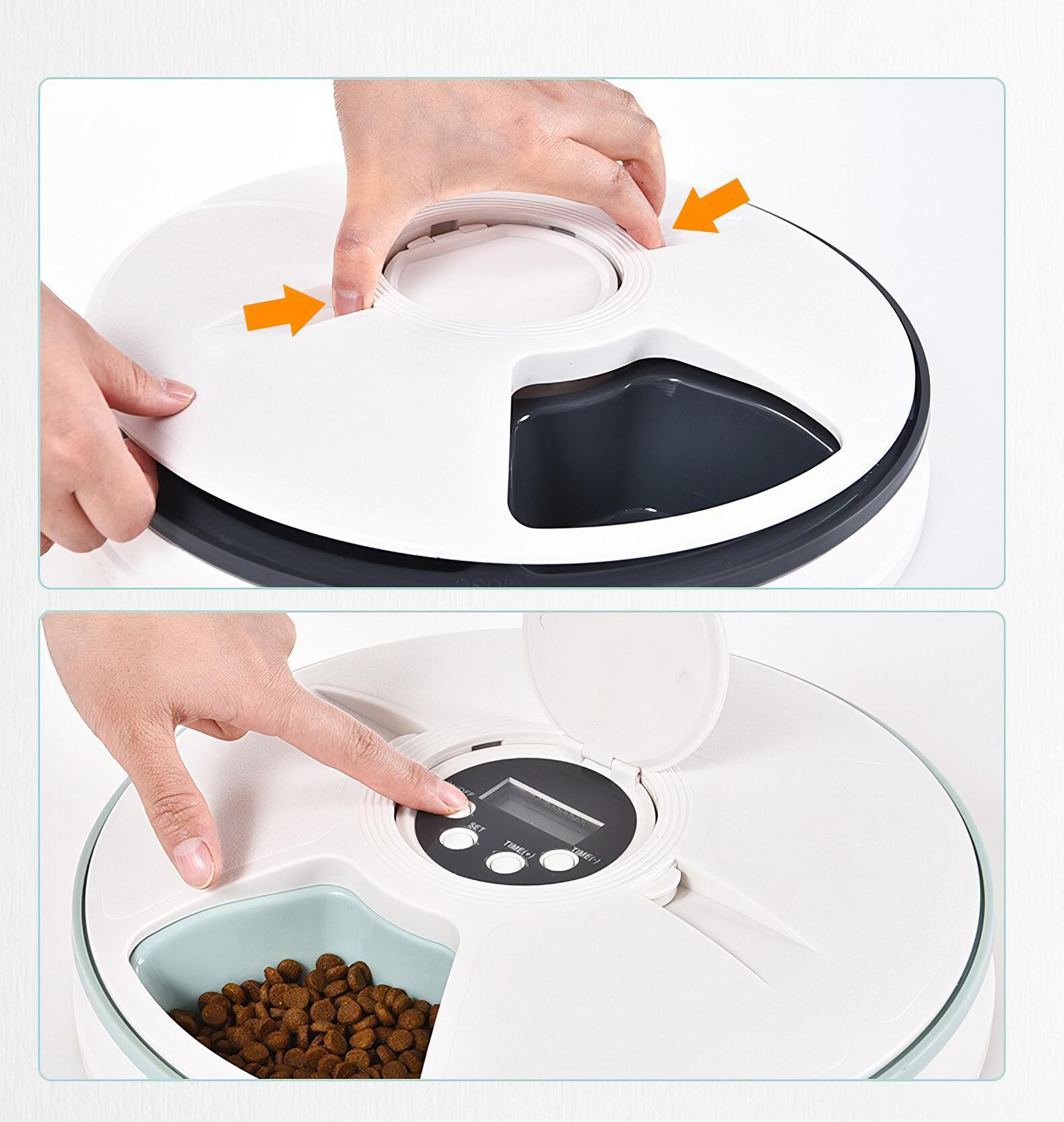 Hände öffnen einen weißen Futterautomaten. Finger drückt eine Taste. Futter befindet sich in einem türkisfarbenen Fach.